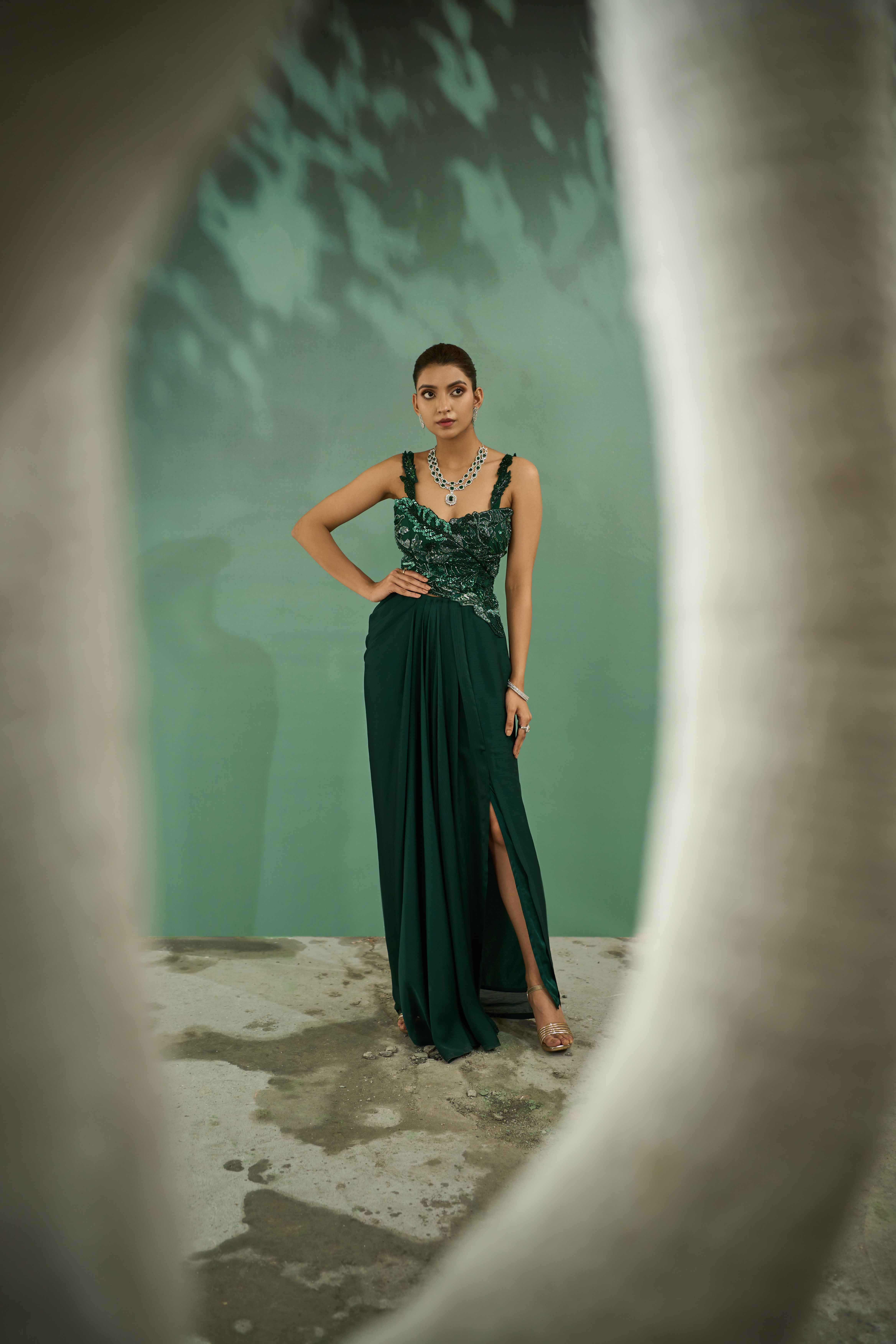 A model showcasing Emerald Green Cutwork Top And Drape Skirt Set by One Knot One from One Knot One's collection