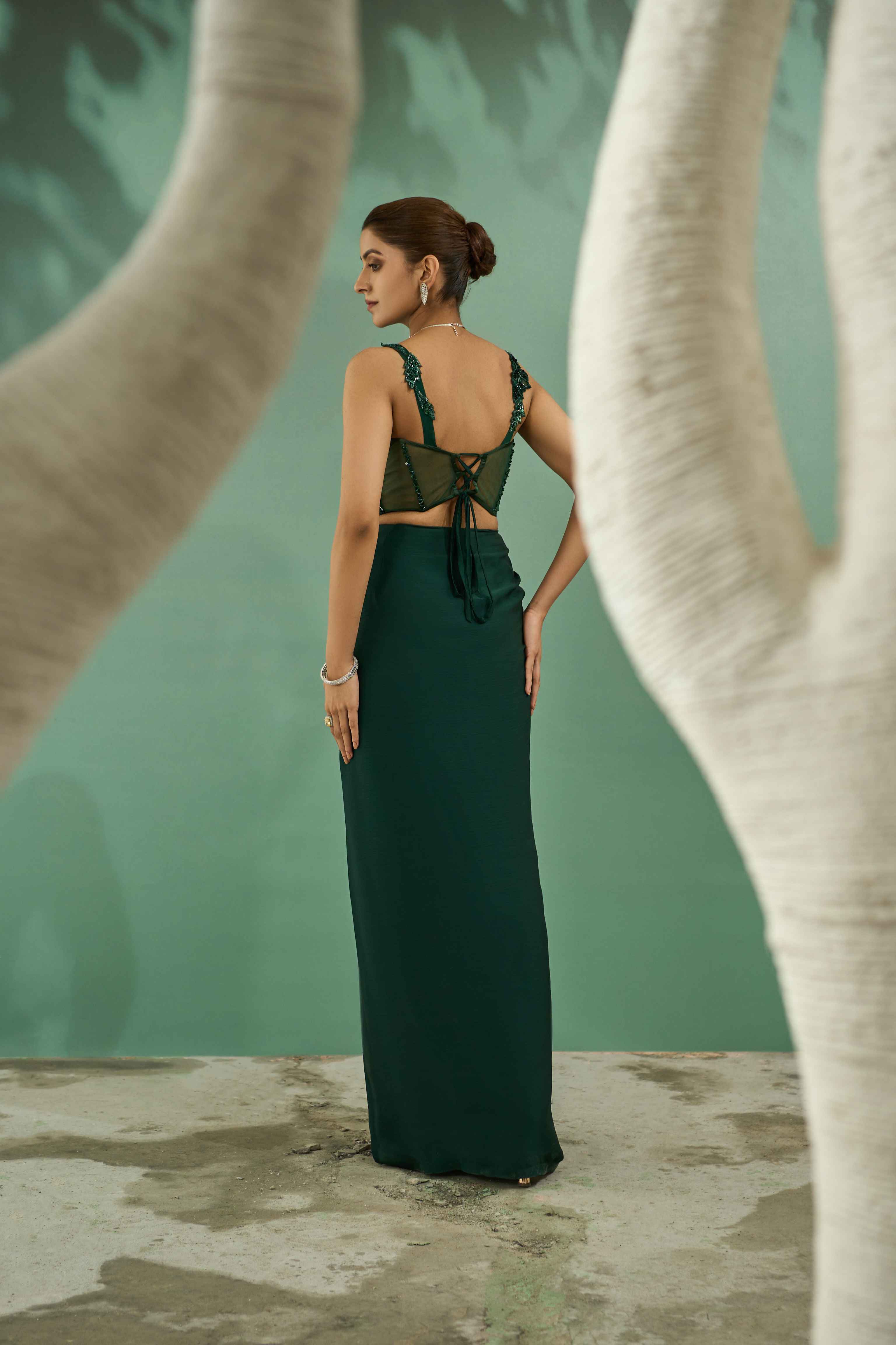 A model showcasing Emerald Green Cutwork Top And Drape Skirt Set by One Knot One from One Knot One's collection