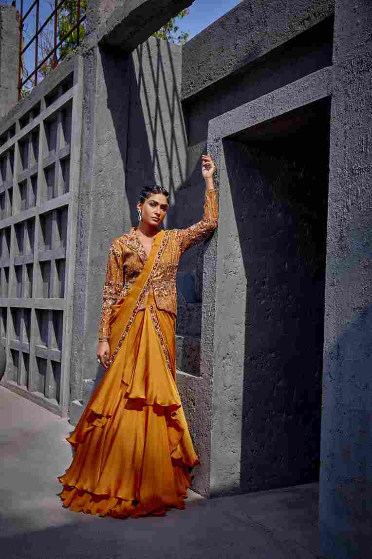 A model showcasing Orange Pre Draped Flared Saree by Miku Kumar from Miku Kumar's collection