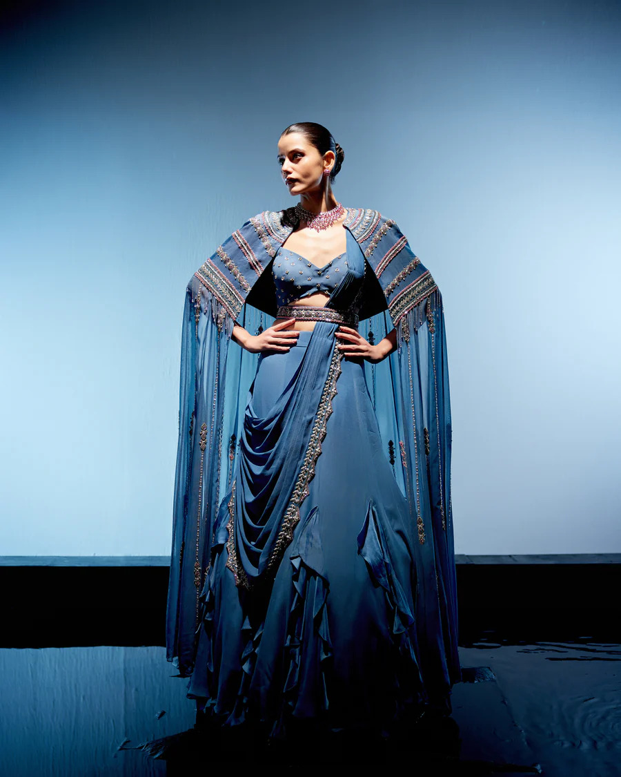 A model showcasing Blue Evelyn Lehenga by Miku Kumar from Miku Kumar's collection
