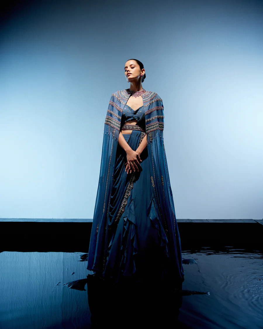A model showcasing Blue Evelyn Lehenga by Miku Kumar from Miku Kumar's collection