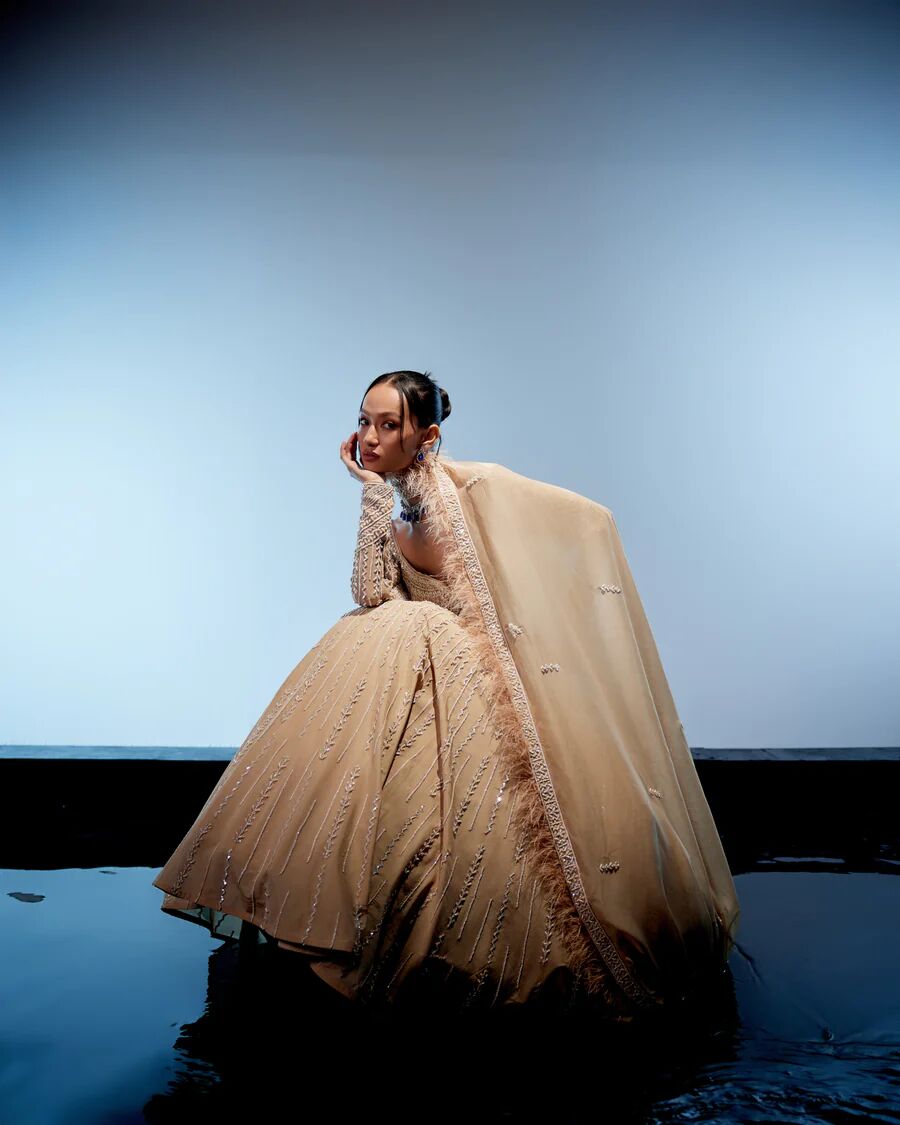 A model showcasing Ivory Olivia Lehenga by Miku Kumar from Miku Kumar's collection