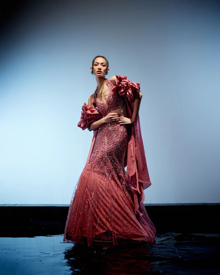 A model showcasing Astro Dust Cerise Lehenga by Miku Kumar from Miku Kumar's collection A model showcasing Astro Dust Cerise Lehenga by Miku Kumar from Miku Kumar's collection