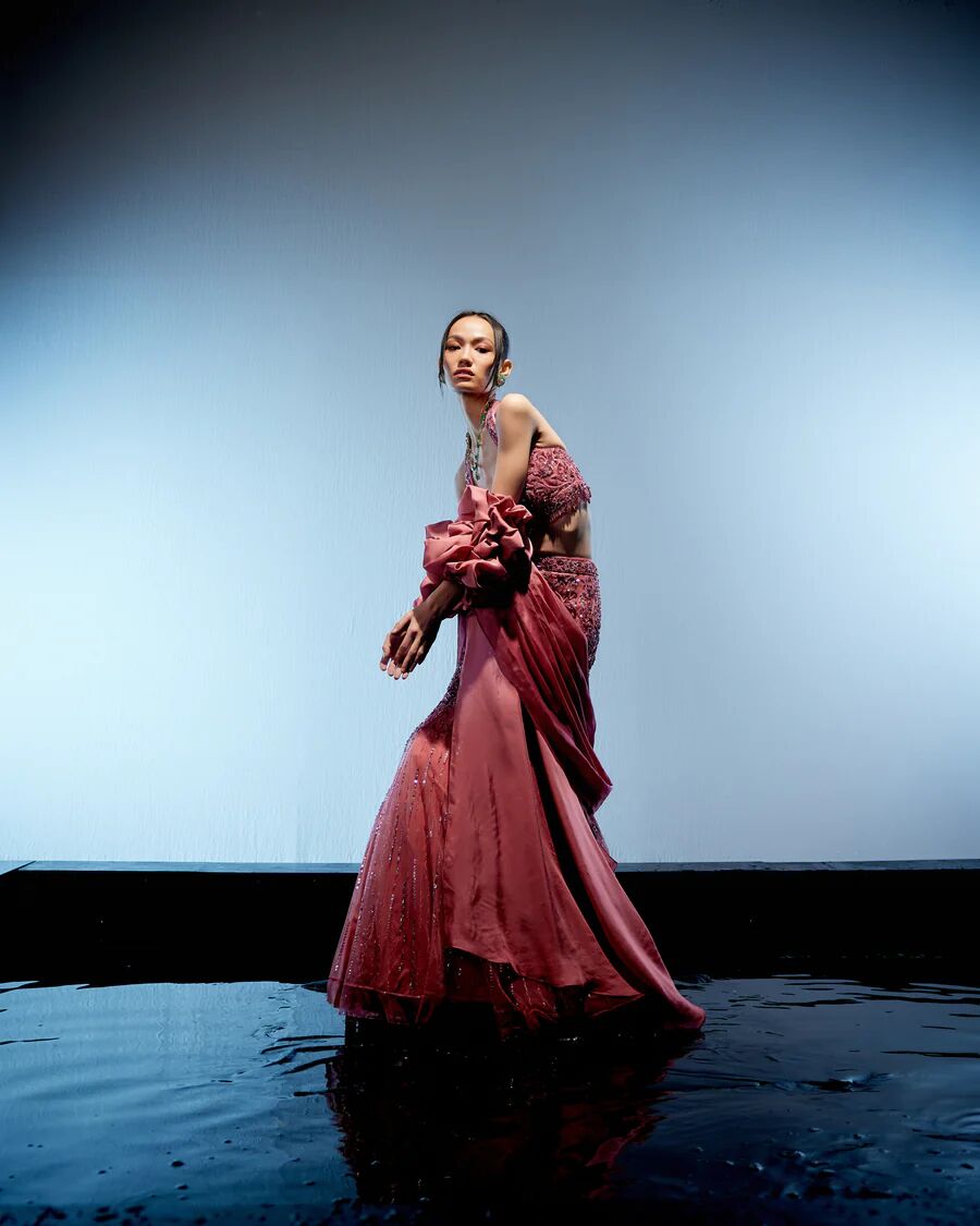 A model showcasing Astro Dust Cerise Lehenga by Miku Kumar from Miku Kumar's collection A model showcasing Astro Dust Cerise Lehenga by Miku Kumar from Miku Kumar's collection