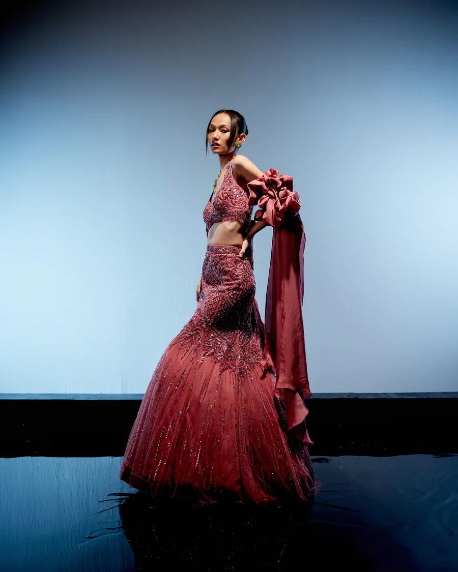A model showcasing Astro Dust Cerise Lehenga by Miku Kumar from Miku Kumar's collection A model showcasing Astro Dust Cerise Lehenga by Miku Kumar from Miku Kumar's collection
