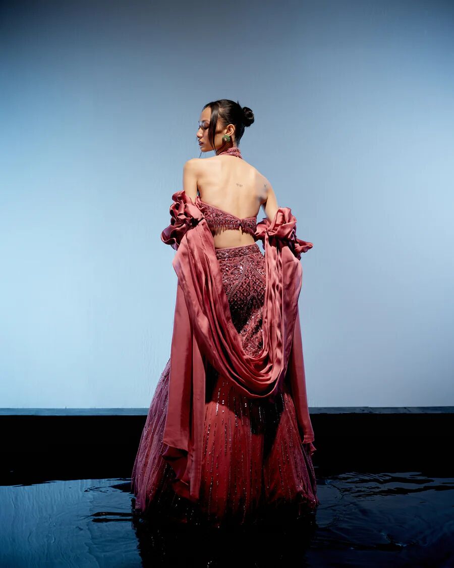 A model showcasing Astro Dust Cerise Lehenga by Miku Kumar from Miku Kumar's collection A model showcasing Astro Dust Cerise Lehenga by Miku Kumar from Miku Kumar's collection