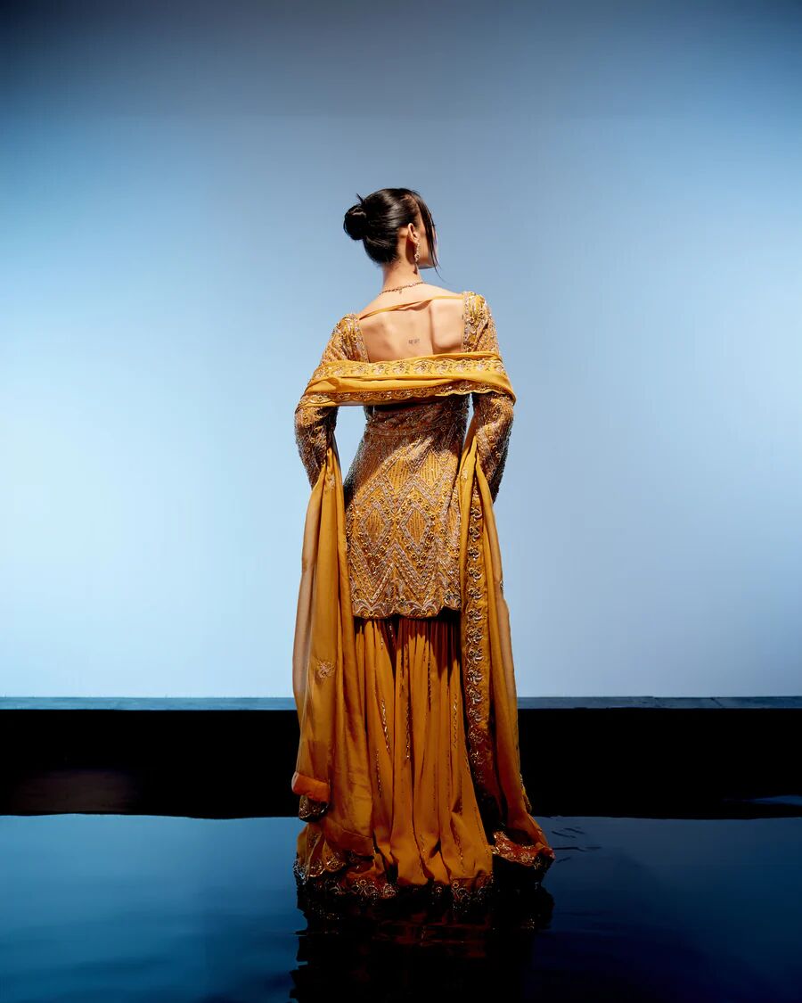 A model showcasing Aurelia Sharara Set by Miku Kumar from Miku Kumar's collection