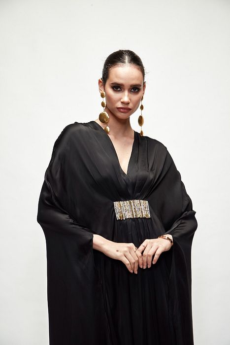 A model showcasing Black Silk Kaftaan by Ranian from Ranian's collection A model showcasing Black Silk Kaftaan by Ranian from Ranian's collection