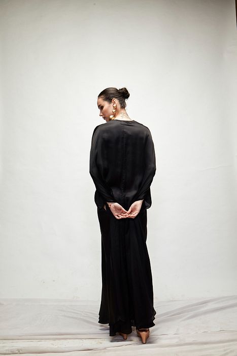A model showcasing Black Silk Kaftaan by Ranian from Ranian's collection A model showcasing Black Silk Kaftaan by Ranian from Ranian's collection