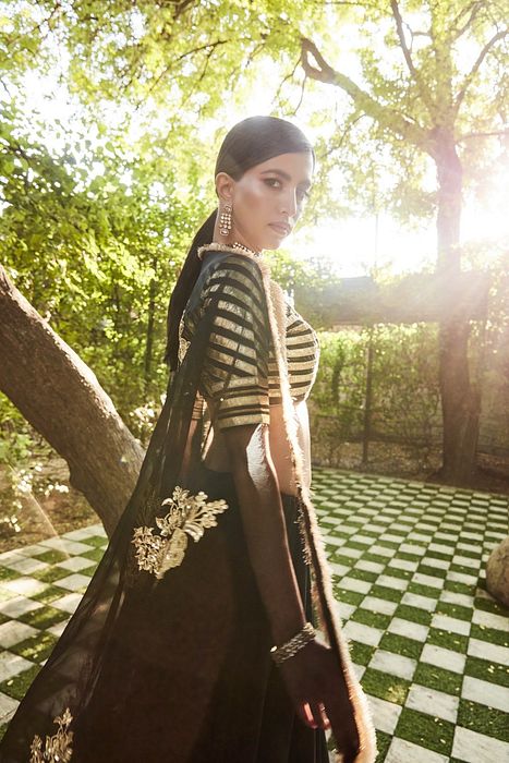 A model showcasing Black Silk Lehenga by Ranian from Ranian's collection A model showcasing Black Silk Lehenga by Ranian from Ranian's collection