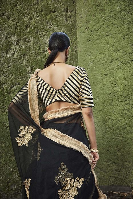 A model showcasing Black Silk Lehenga by Ranian from Ranian's collection A model showcasing Black Silk Lehenga by Ranian from Ranian's collection