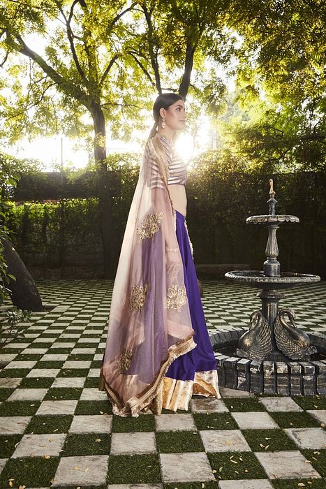A model showcasing Purple Silk Lehenga by Ranian from Ranian's collection A model showcasing Purple Silk Lehenga by Ranian from Ranian's collection