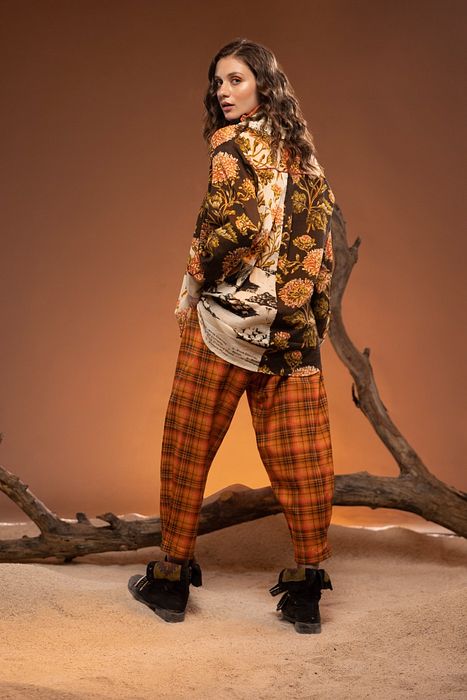 A model showcasing Orange Black Check Pants by Capisvirleo from Capisvirleo's collection A model showcasing Orange Black Check Pants by Capisvirleo from Capisvirleo's collection