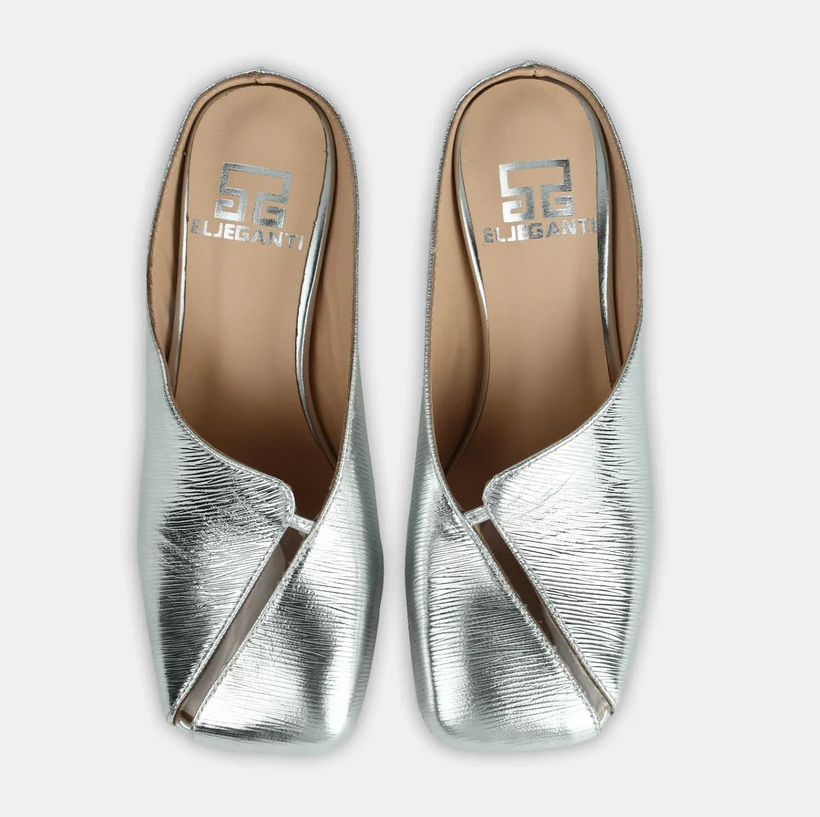 A model showcasing Silver Colored Leather Mule Sandals by Elleganti from Elleganti's collection A model showcasing Silver Colored Leather Mule Sandals by Elleganti from Elleganti's collection