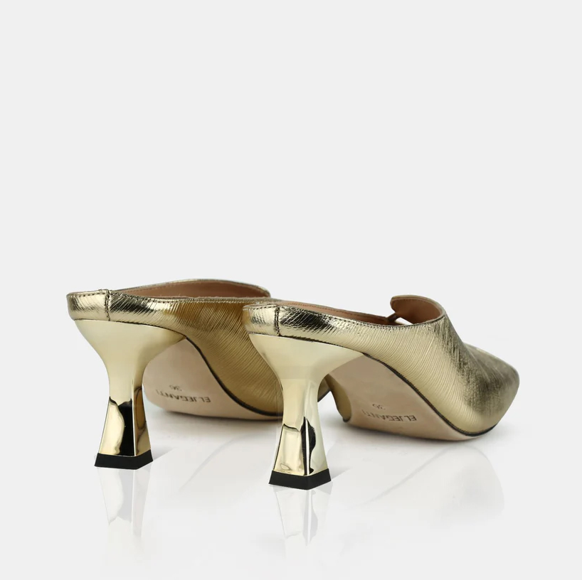 A model showcasing Gold Colored Leather Mule Sandals by Elleganti from Elleganti's collection A model showcasing Gold Colored Leather Mule Sandals by Elleganti from Elleganti's collection