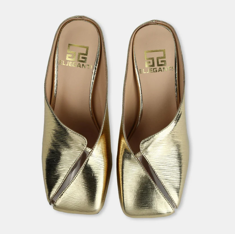 A model showcasing Gold Colored Leather Mule Sandals by Elleganti from Elleganti's collection A model showcasing Gold Colored Leather Mule Sandals by Elleganti from Elleganti's collection