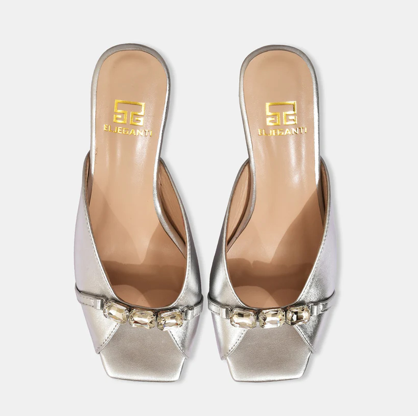 A model showcasing Silver Metallic Leather Sandals With Crystal Heel by Elleganti from Elleganti's collection A model showcasing Silver Metallic Leather Sandals With Crystal Heel by Elleganti from Elleganti's collection