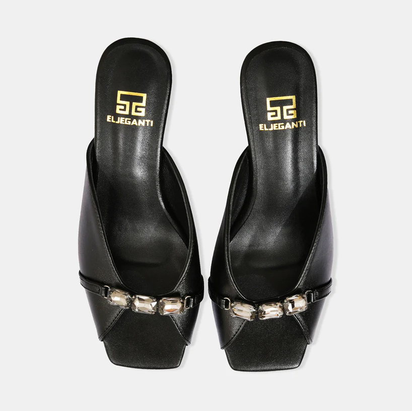 A model showcasing Black Metallic Leather Sandals With Crystal Heel by Elleganti from Elleganti's collection A model showcasing Black Metallic Leather Sandals With Crystal Heel by Elleganti from Elleganti's collection