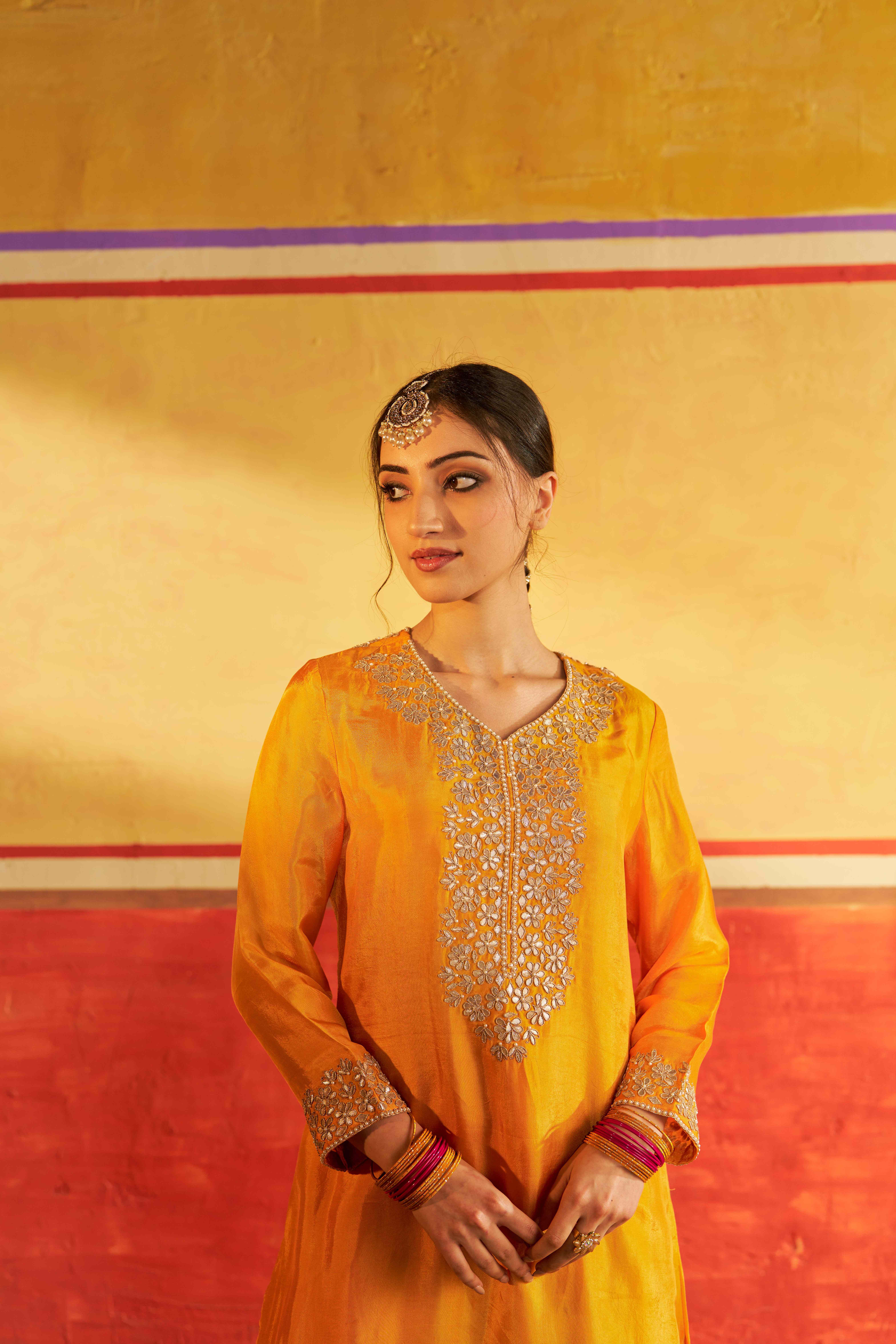 A model showcasing Miraas Yellow Kurta Suit With Dupatta by Gaamya from Gaamya's collection