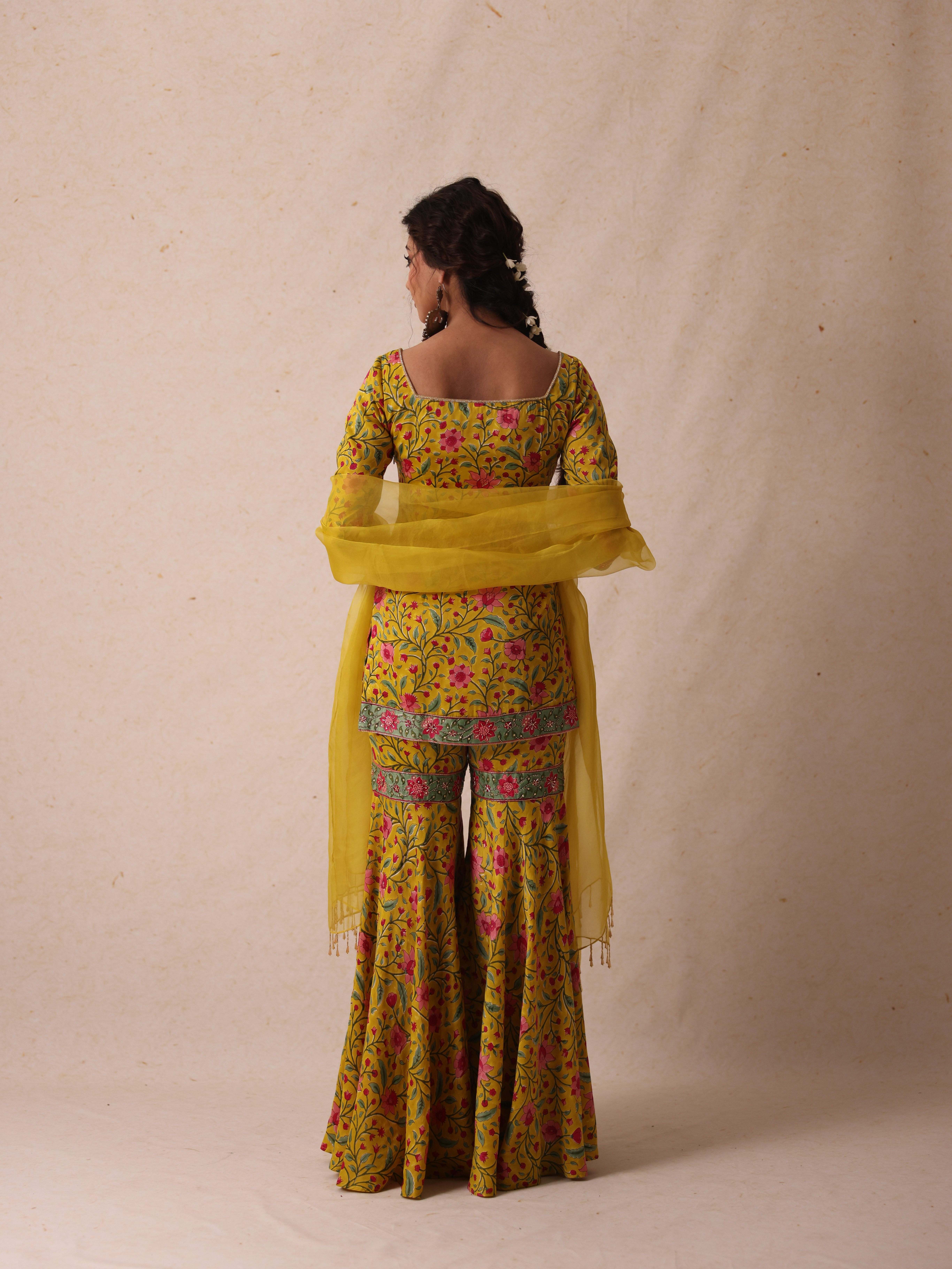 A model showcasing Simar Yellow Sharara Set by Gaamya from Gaamya's collection