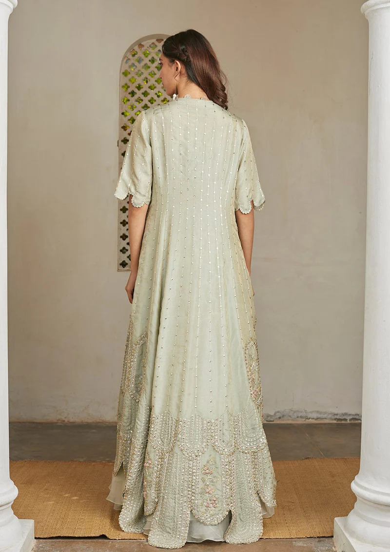 A model showcasing Ivory Optical Embroidered Jacket Lehenga Set by Ossa from Ossa's collection A model showcasing Ivory Optical Embroidered Jacket Lehenga Set by Ossa from Ossa's collection