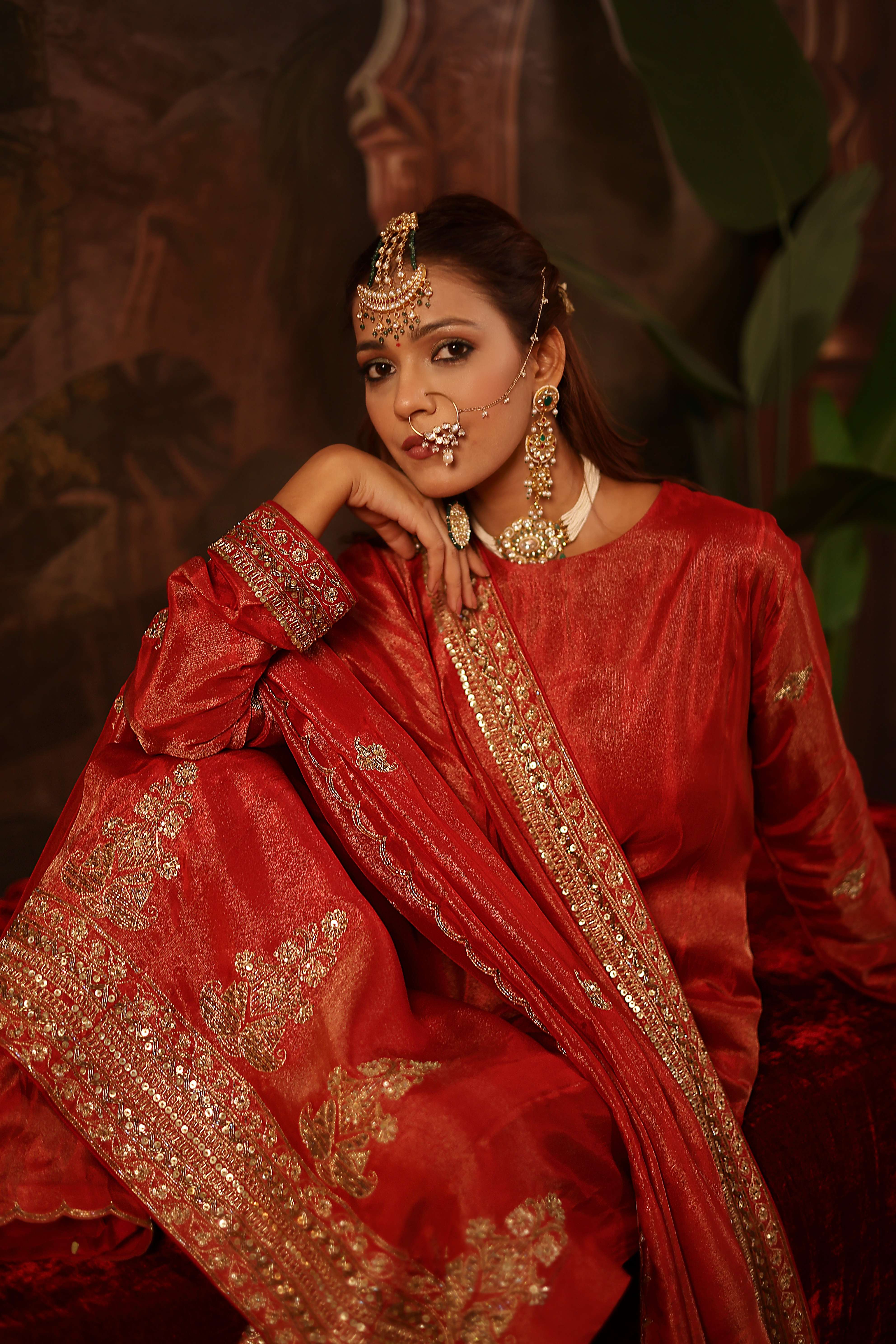 A model showcasing Prisha Red Suit Set by Miku Kumar from Miku Kumar's collection