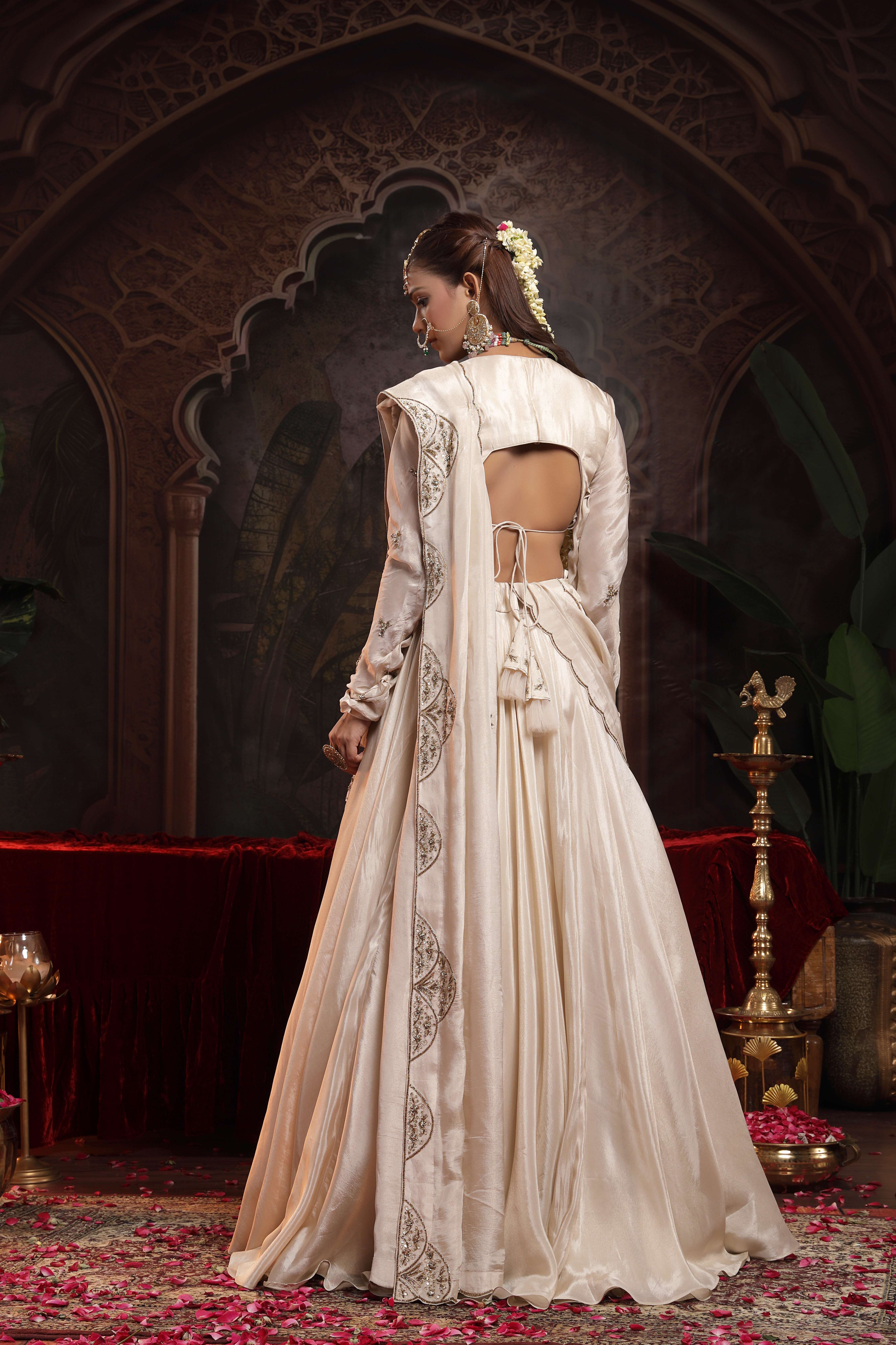 A model showcasing Nihar Ivory Lehenga Set by Miku Kumar from Miku Kumar's collection