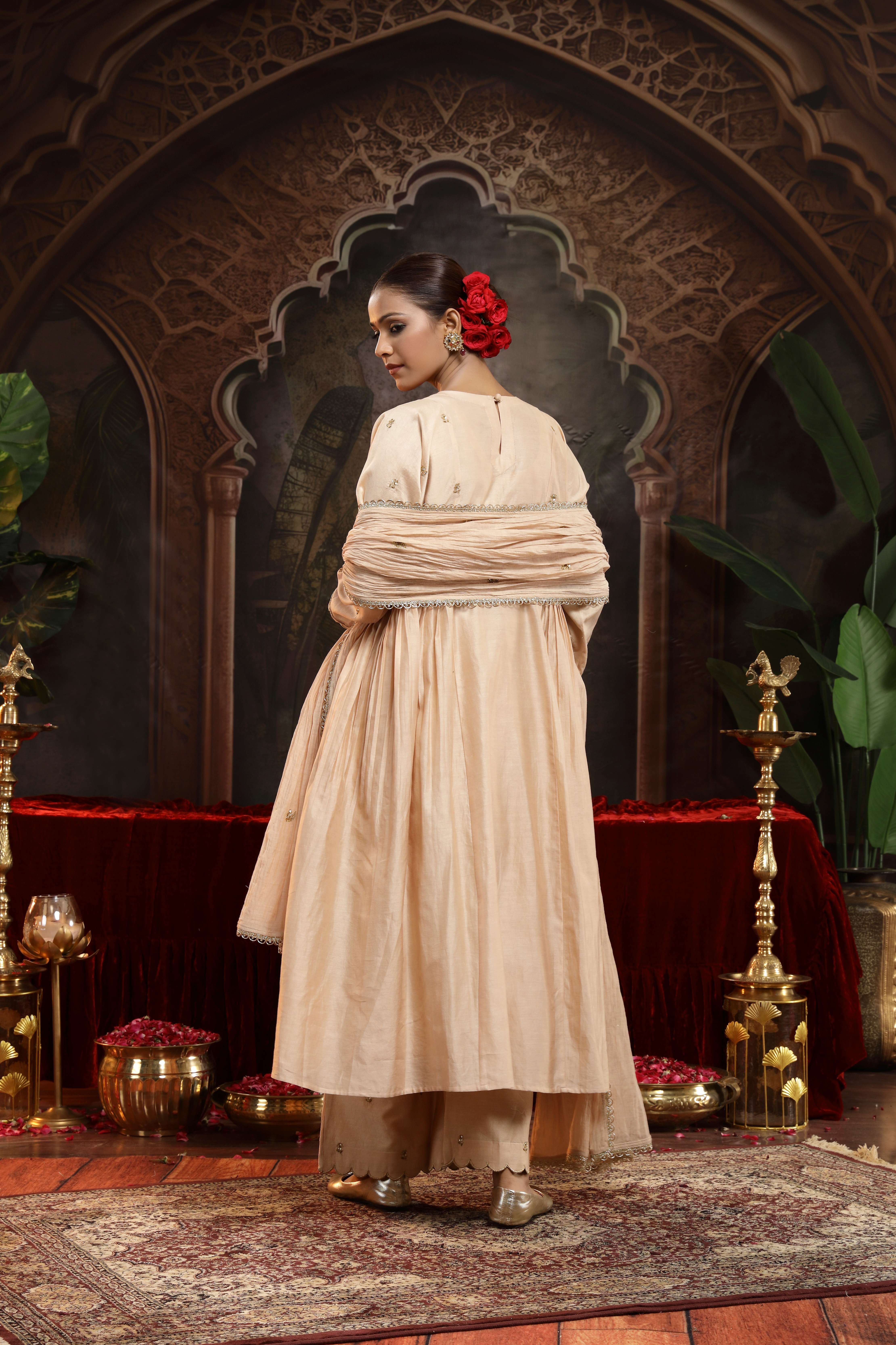 A model showcasing Sharvi Ivory Chanderi Silk Suit by Miku Kumar from Miku Kumar's collection