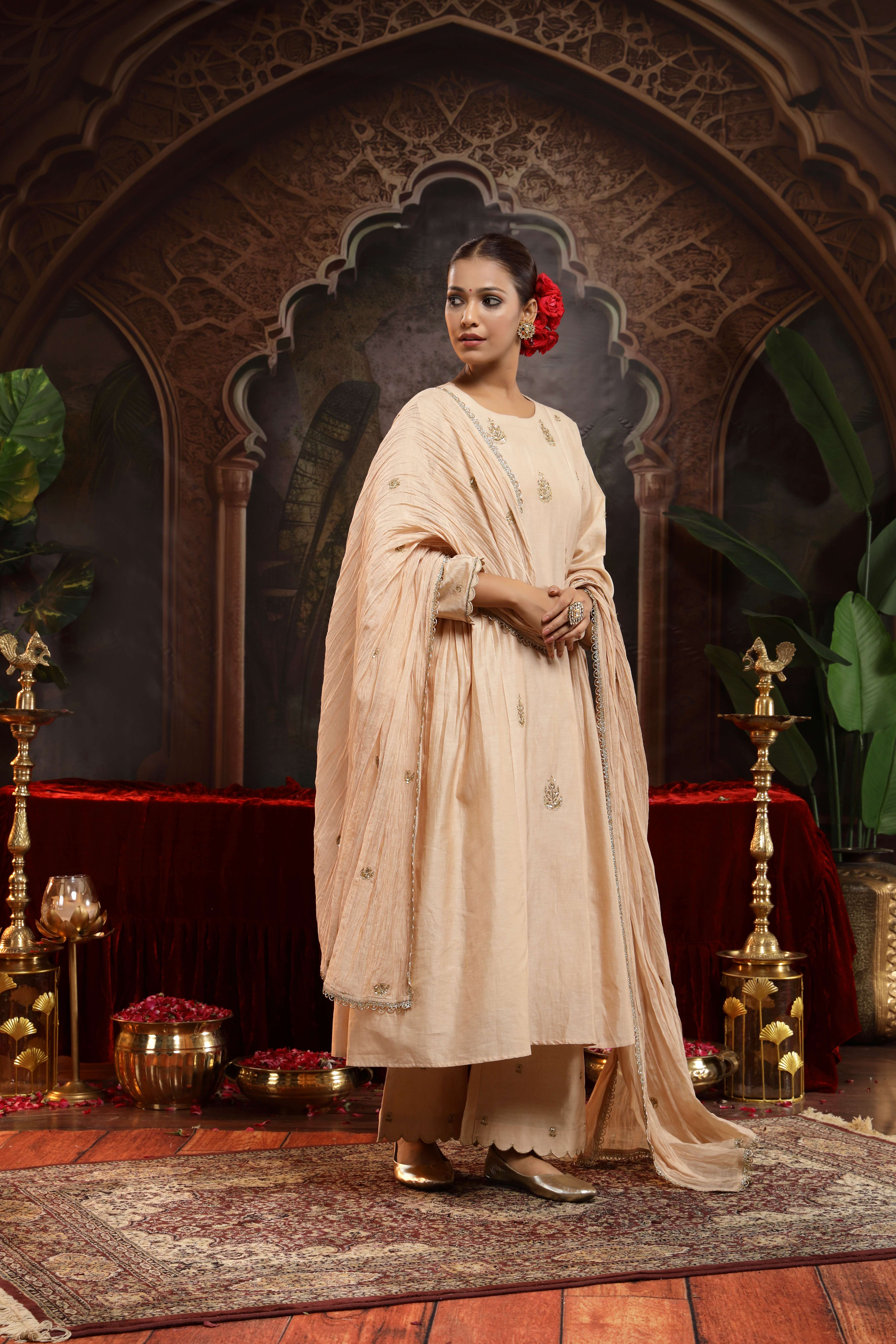 A model showcasing Sharvi Ivory Chanderi Silk Suit by Miku Kumar from Miku Kumar's collection