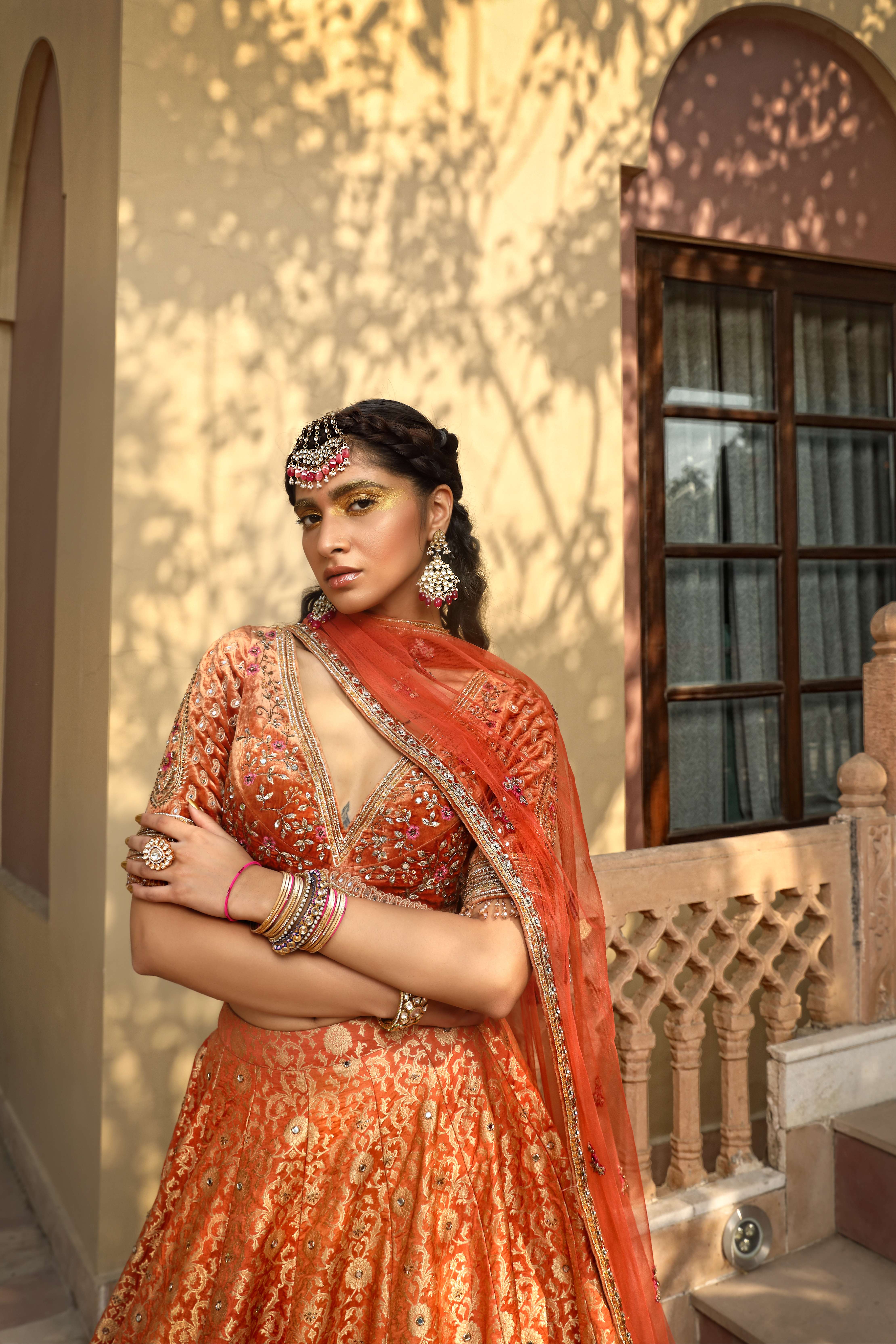 A model showcasing Rust Lehenga Choli Set by Mavish from Mavish's collection