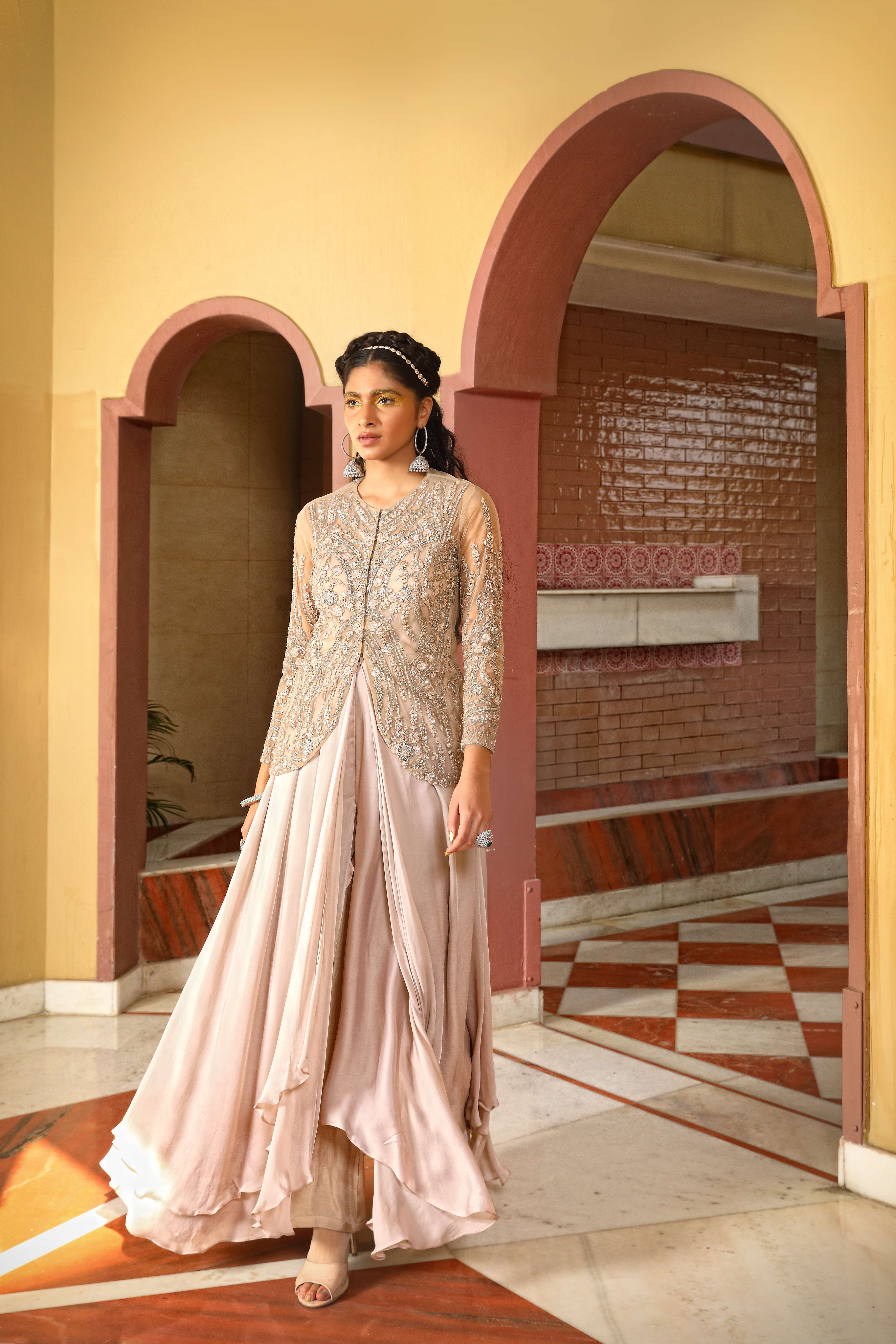 A model showcasing Champagne Layered Gown Sharara Jacket Set by Mavish from Mavish's collection