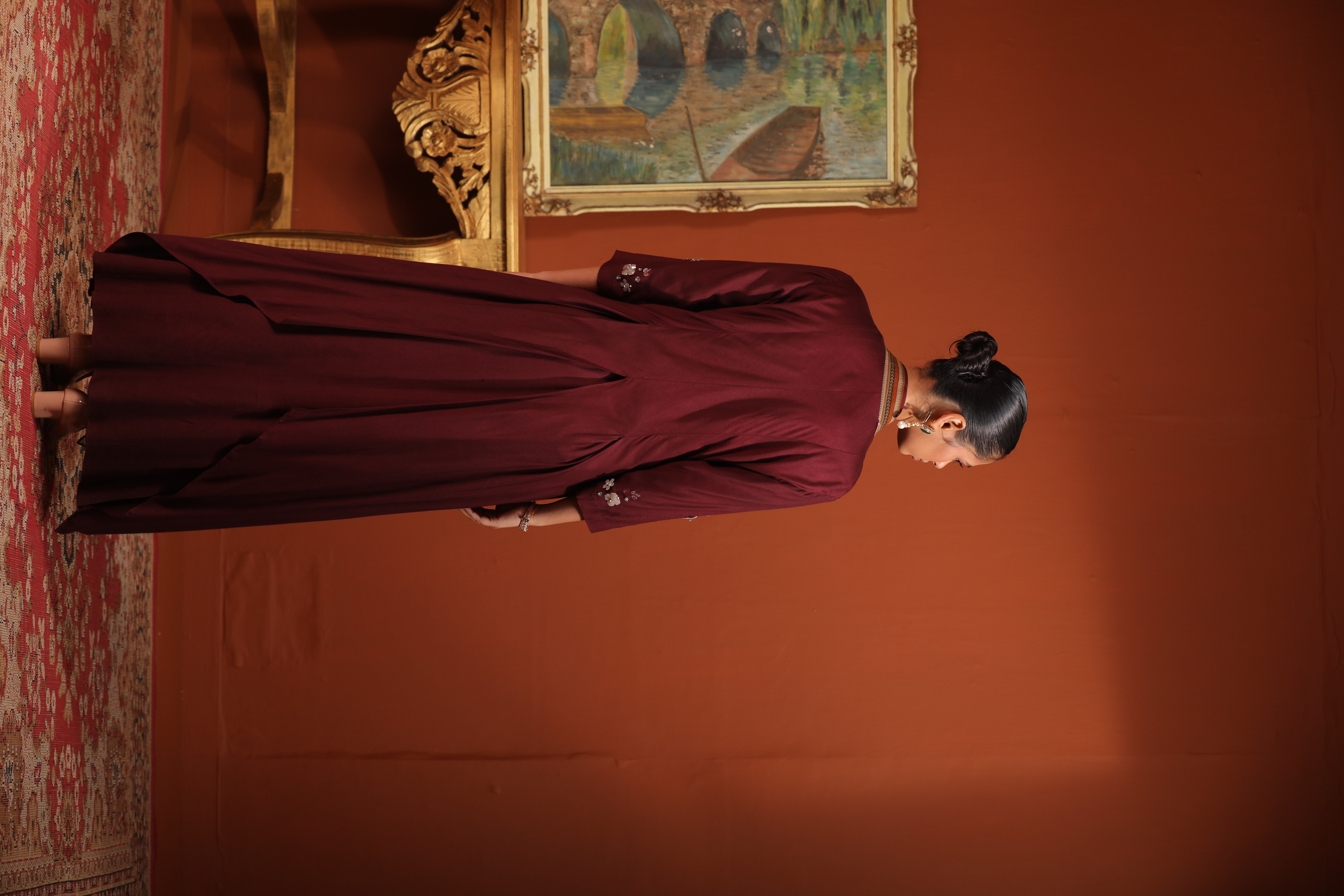 A model showcasing Maroon Layered Drape Anarkali by Mavish from Mavish's collection