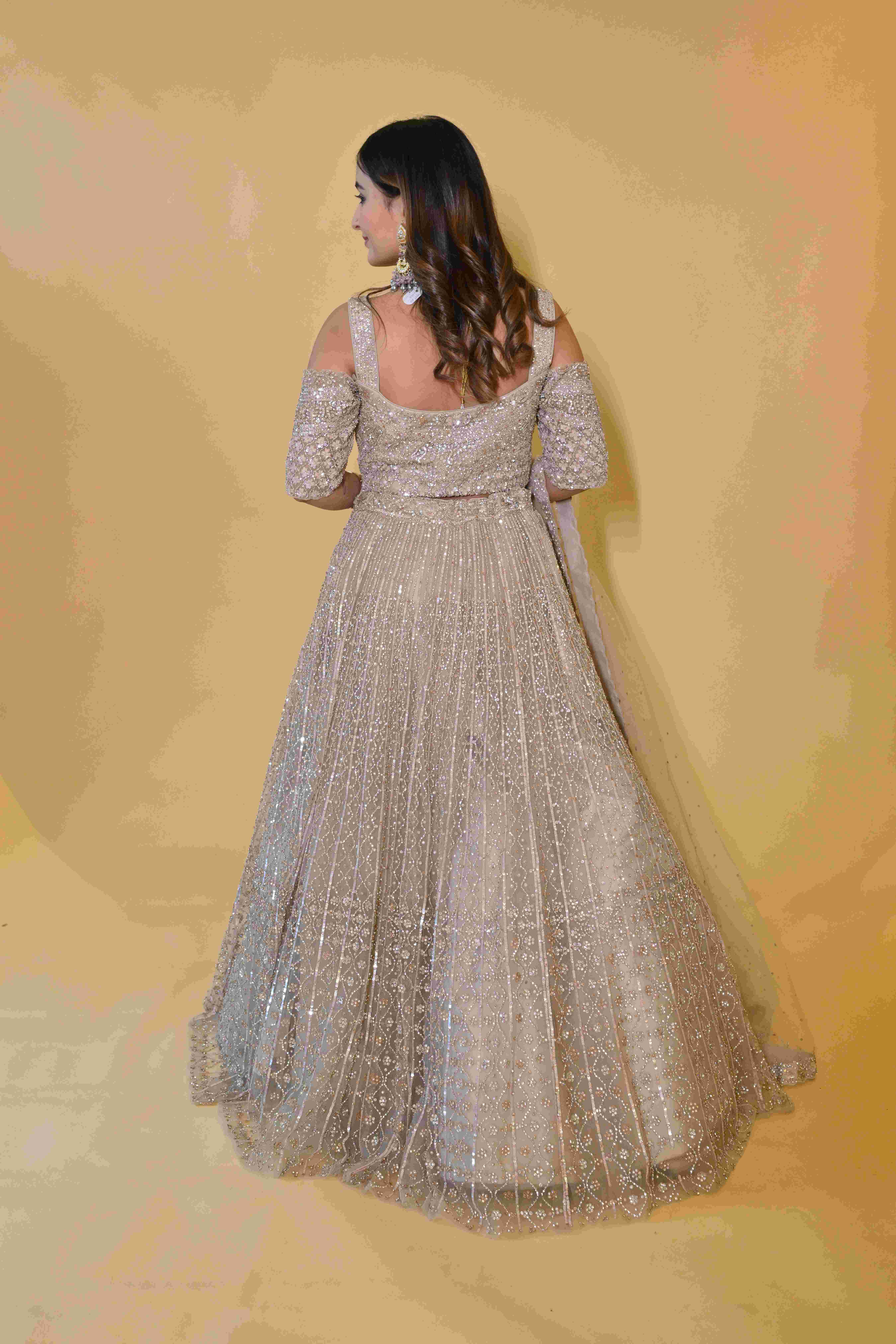 A model showcasing Beige Lehenga Choli Set by Labell Patchouli from Labell Patchouli's collection A model showcasing Beige Lehenga Choli Set by Labell Patchouli from Labell Patchouli's collection