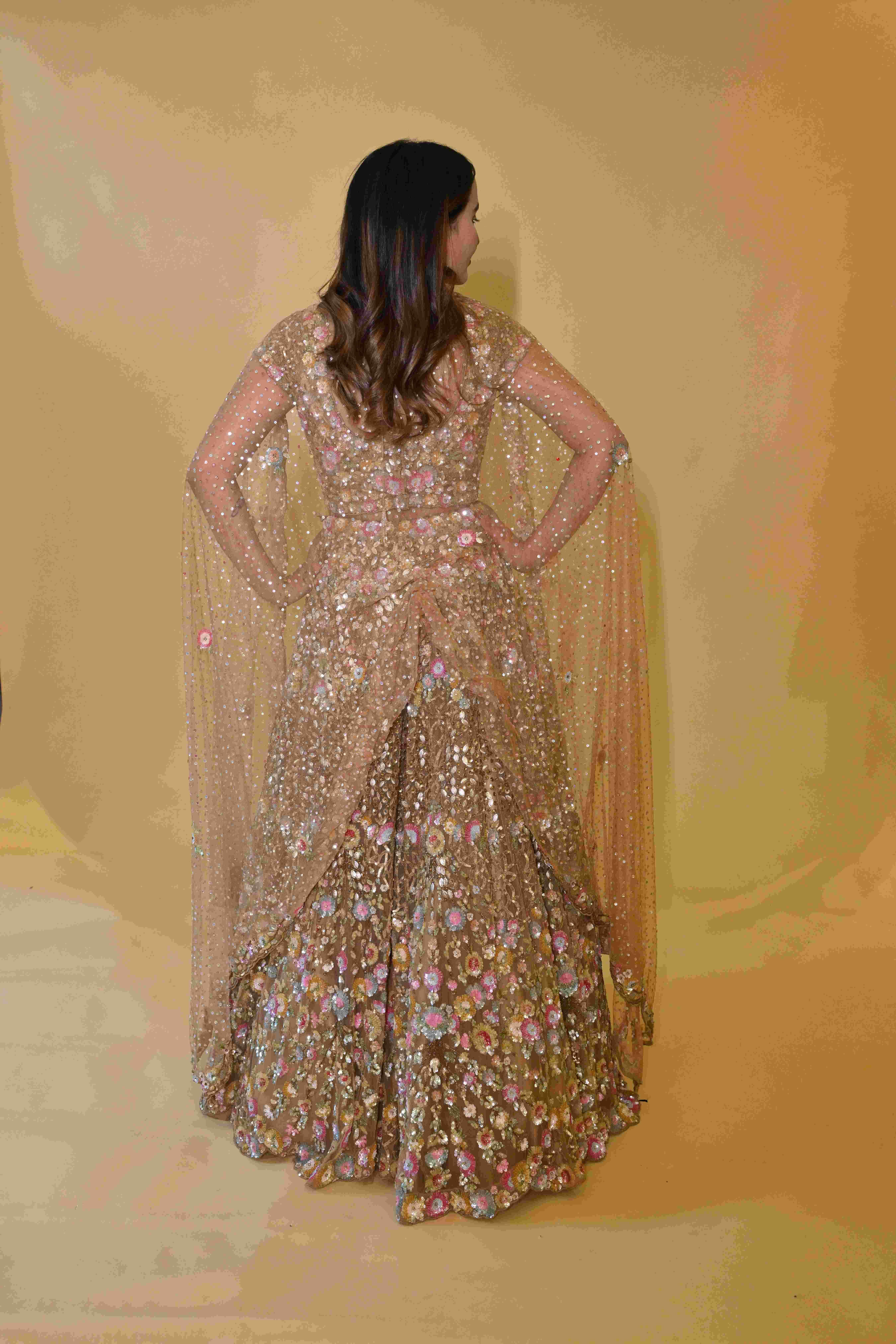 A model showcasing Golden Embroidered Lehenga Choli Set by Labell Patchouli from Labell Patchouli's collection A model showcasing Golden Embroidered Lehenga Choli Set by Labell Patchouli from Labell Patchouli's collection
