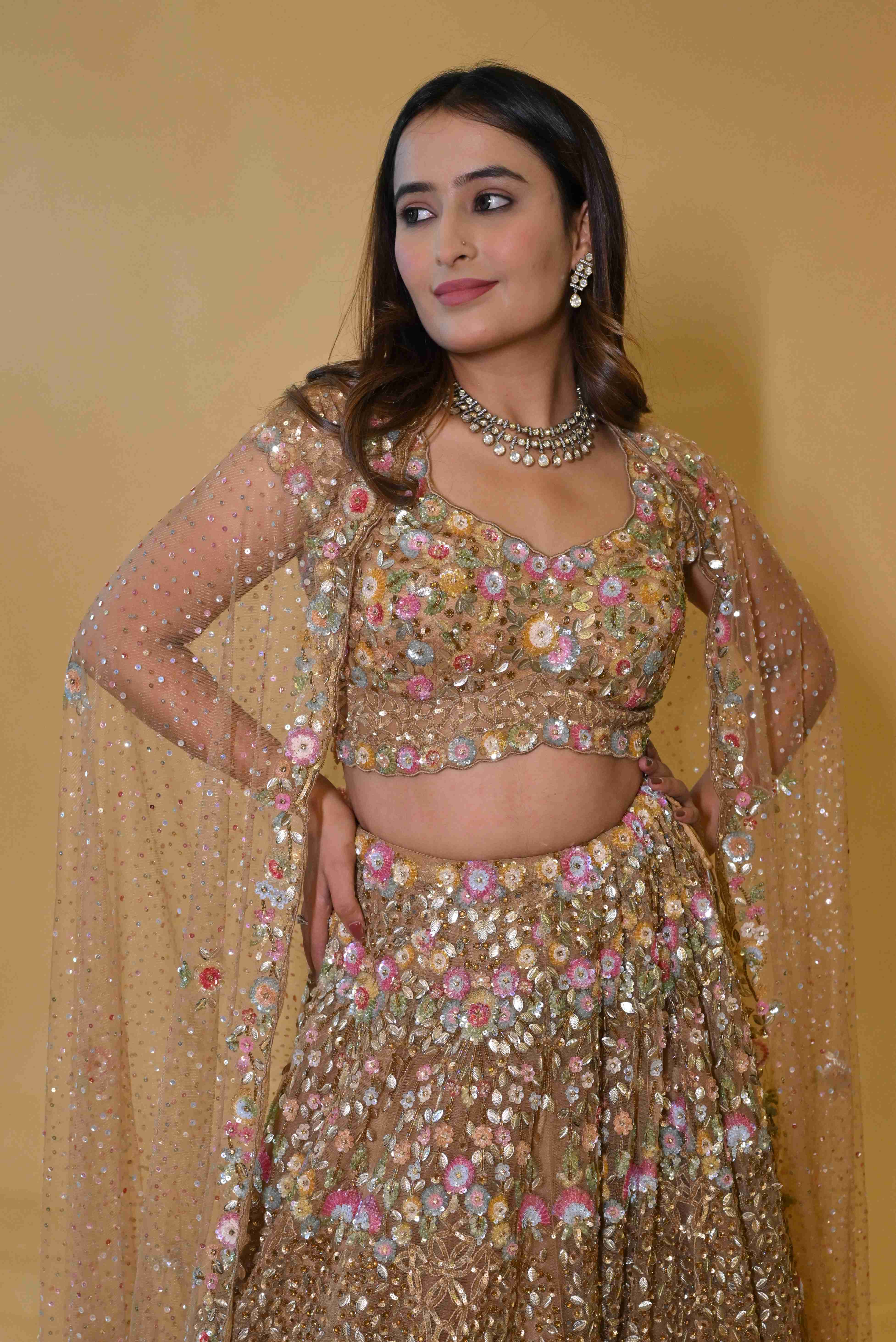 A model showcasing Golden Embroidered Lehenga Choli Set by Labell Patchouli from Labell Patchouli's collection A model showcasing Golden Embroidered Lehenga Choli Set by Labell Patchouli from Labell Patchouli's collection