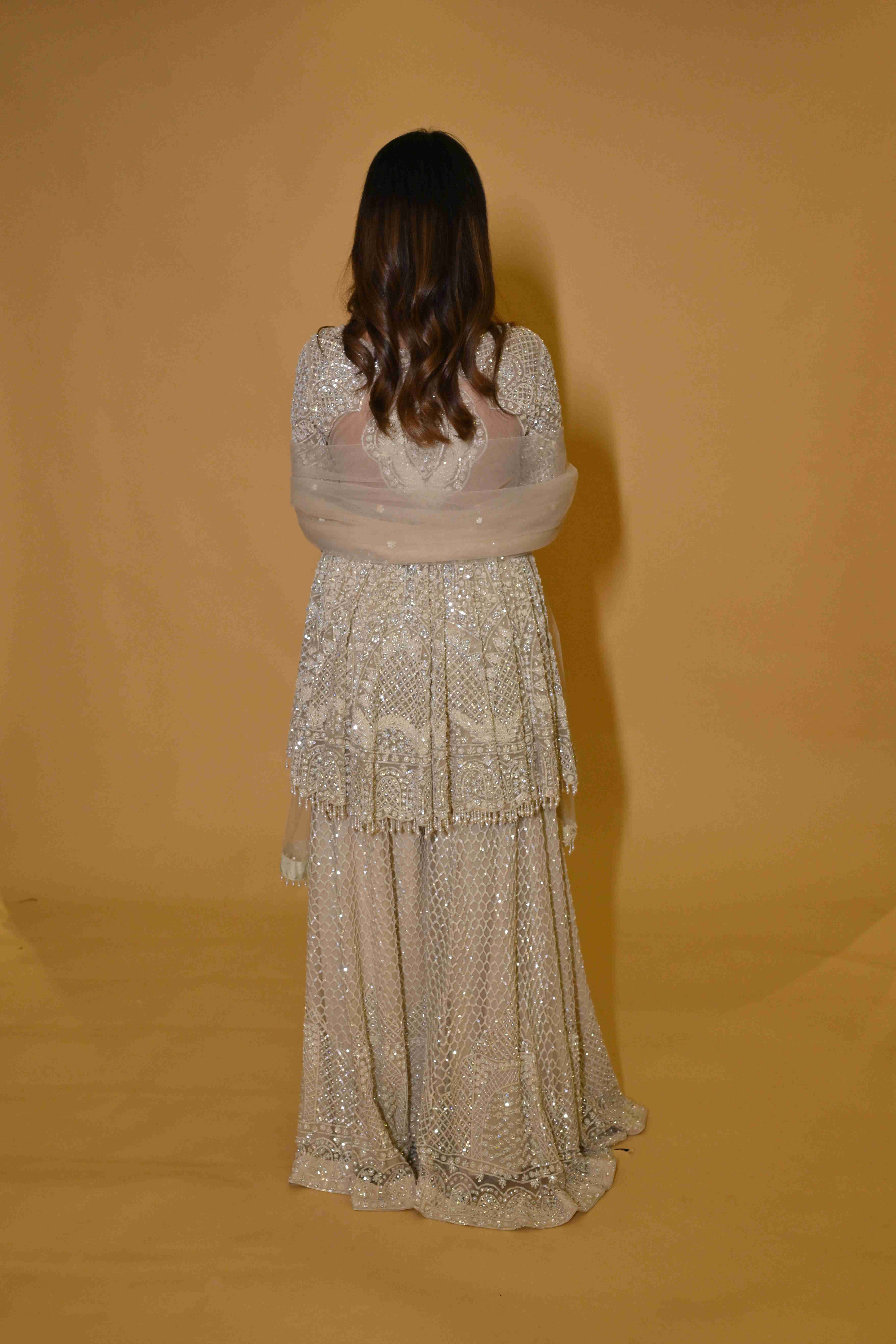 A model showcasing Ivory Peplum Suit by Labell Patchouli from Labell Patchouli's collection A model showcasing Ivory Peplum Suit by Labell Patchouli from Labell Patchouli's collection
