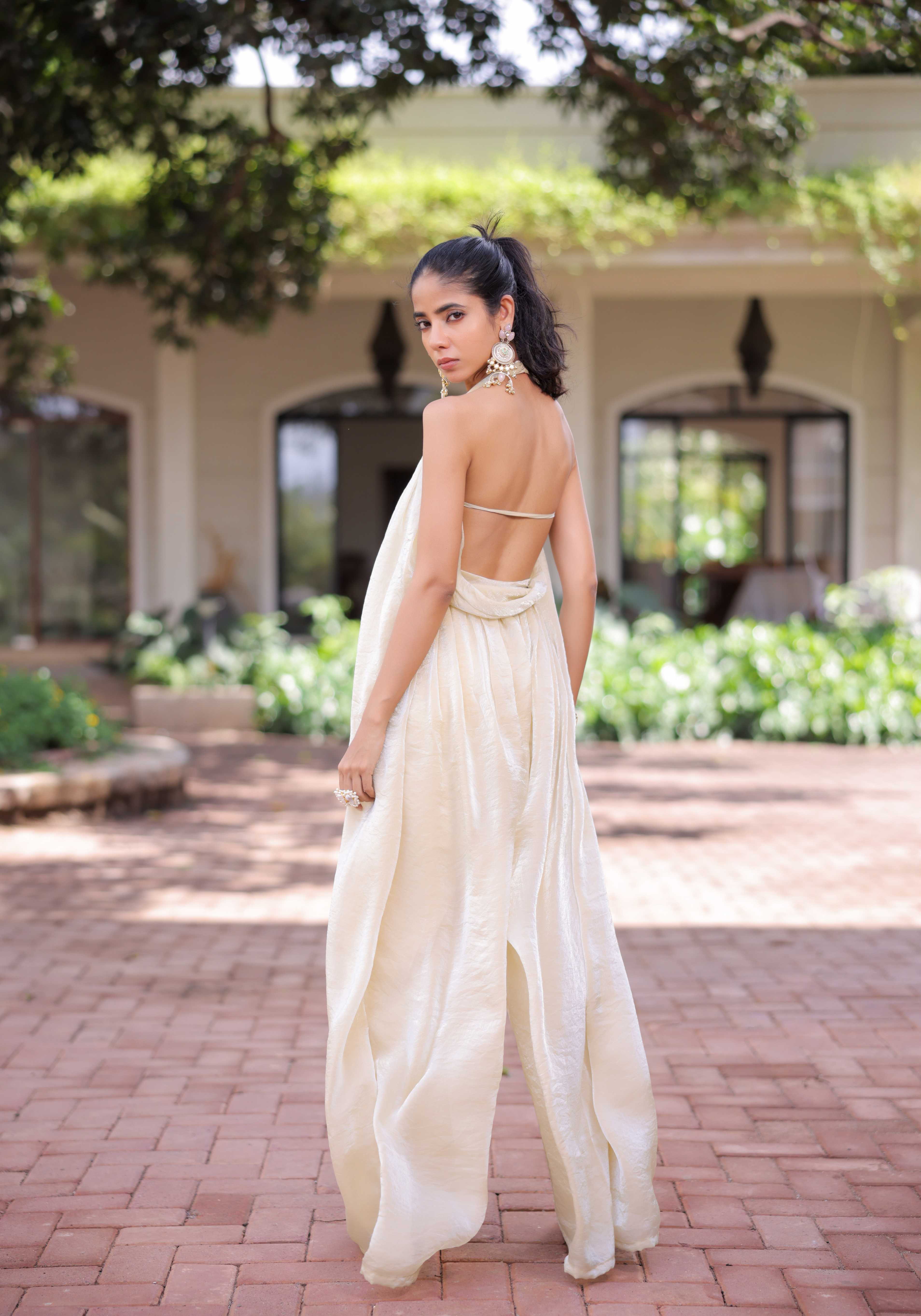 A model showcasing Cream Shimmer Pleated Jumpsuit by Foram Patel from Foram Patel's collection