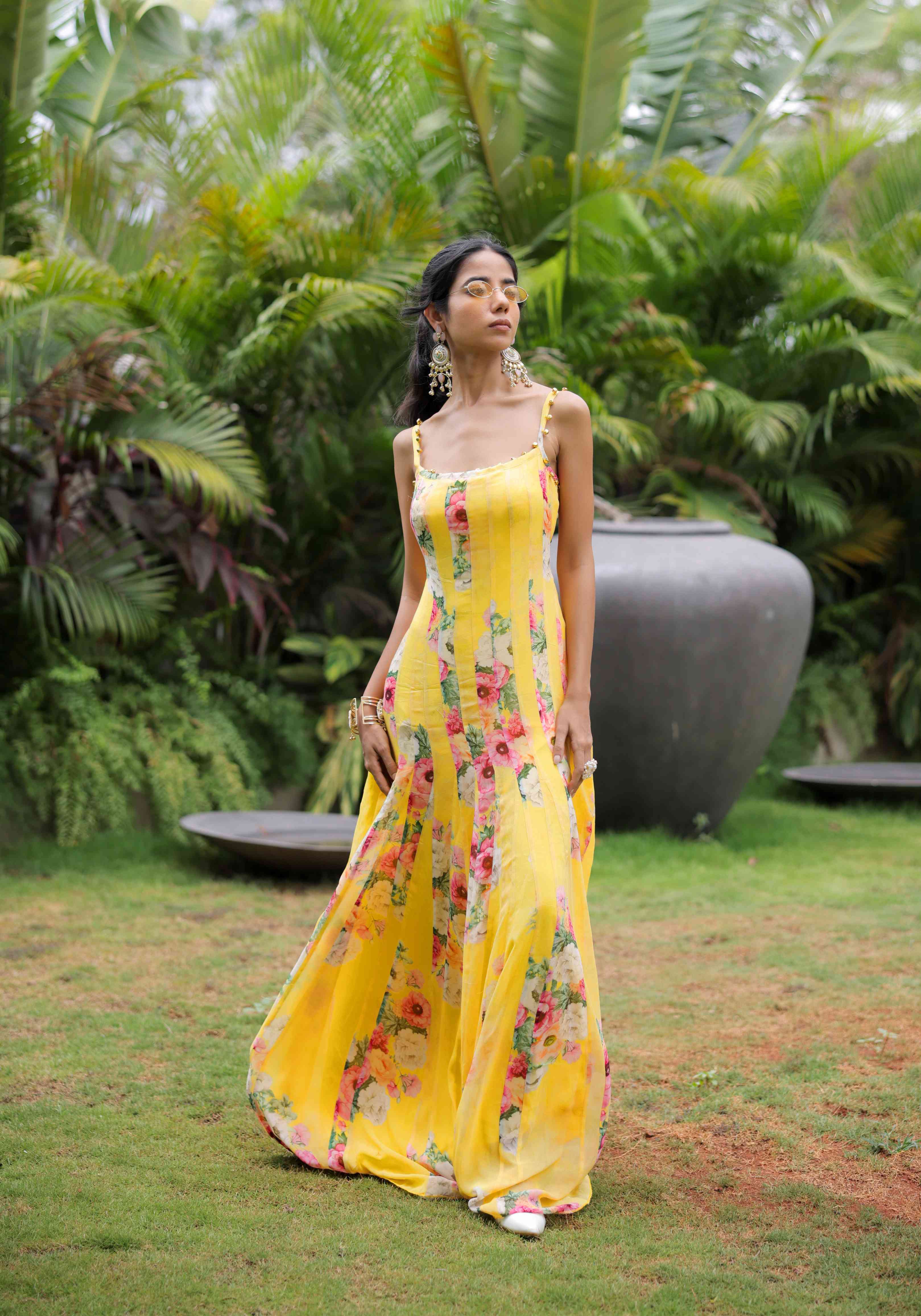 A model showcasing Yellow Floral Printed Pleated Maxi Dress by Foram Patel from Foram Patel's collection