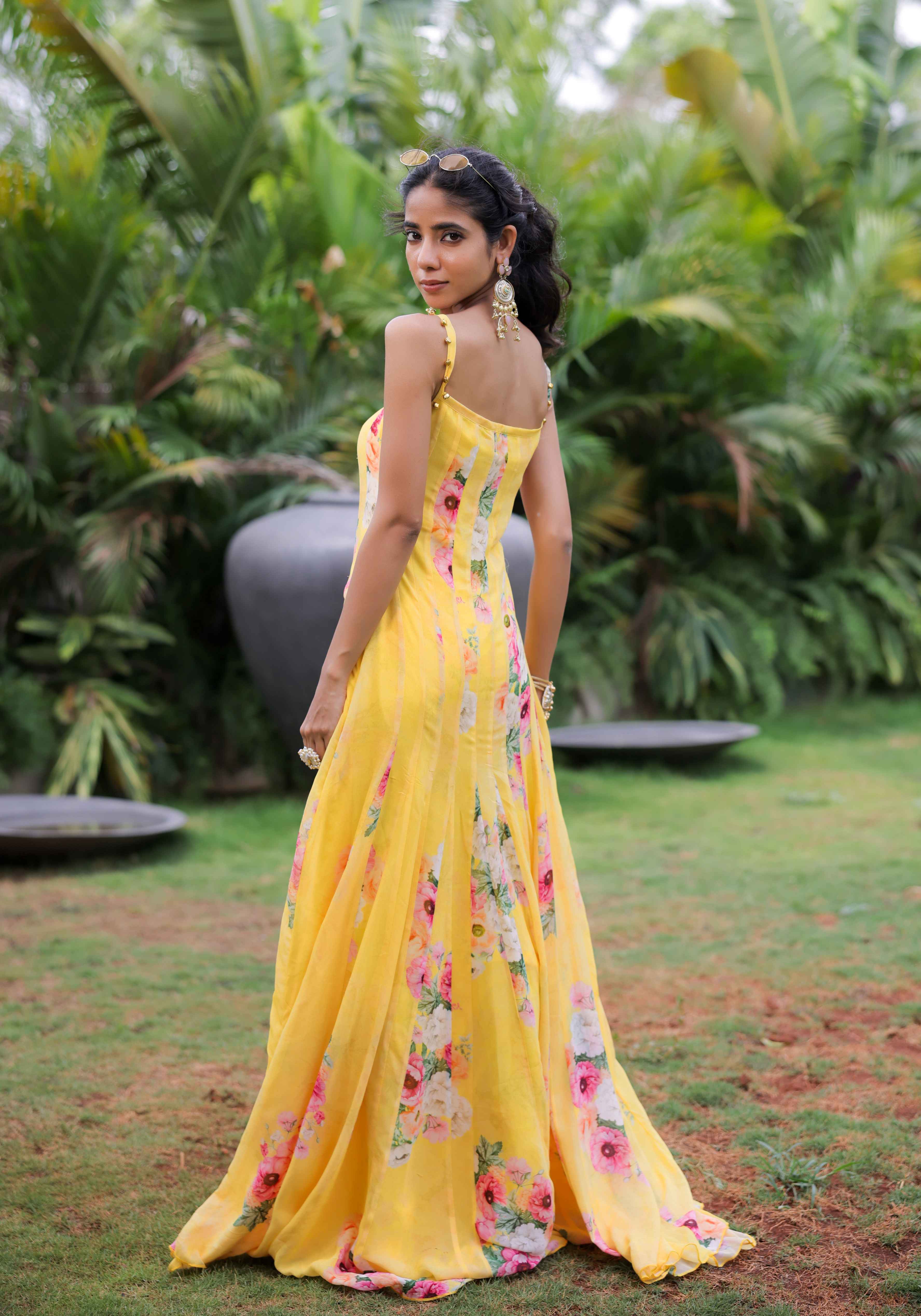 A model showcasing Yellow Floral Printed Pleated Maxi Dress by Foram Patel from Foram Patel's collection