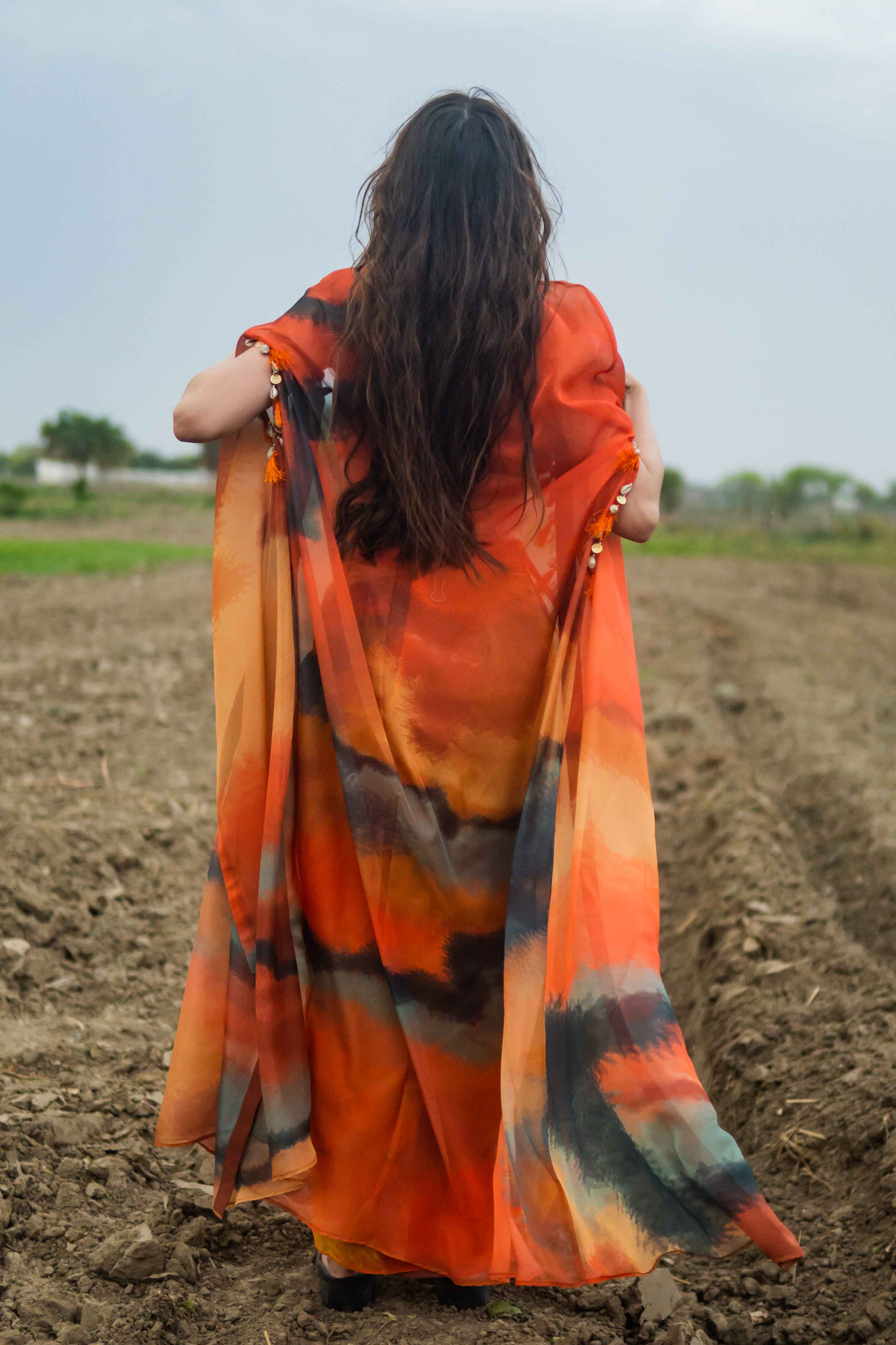 A model showcasing Amber Drift Cape Set by Miku Kumar from Miku Kumar's collection