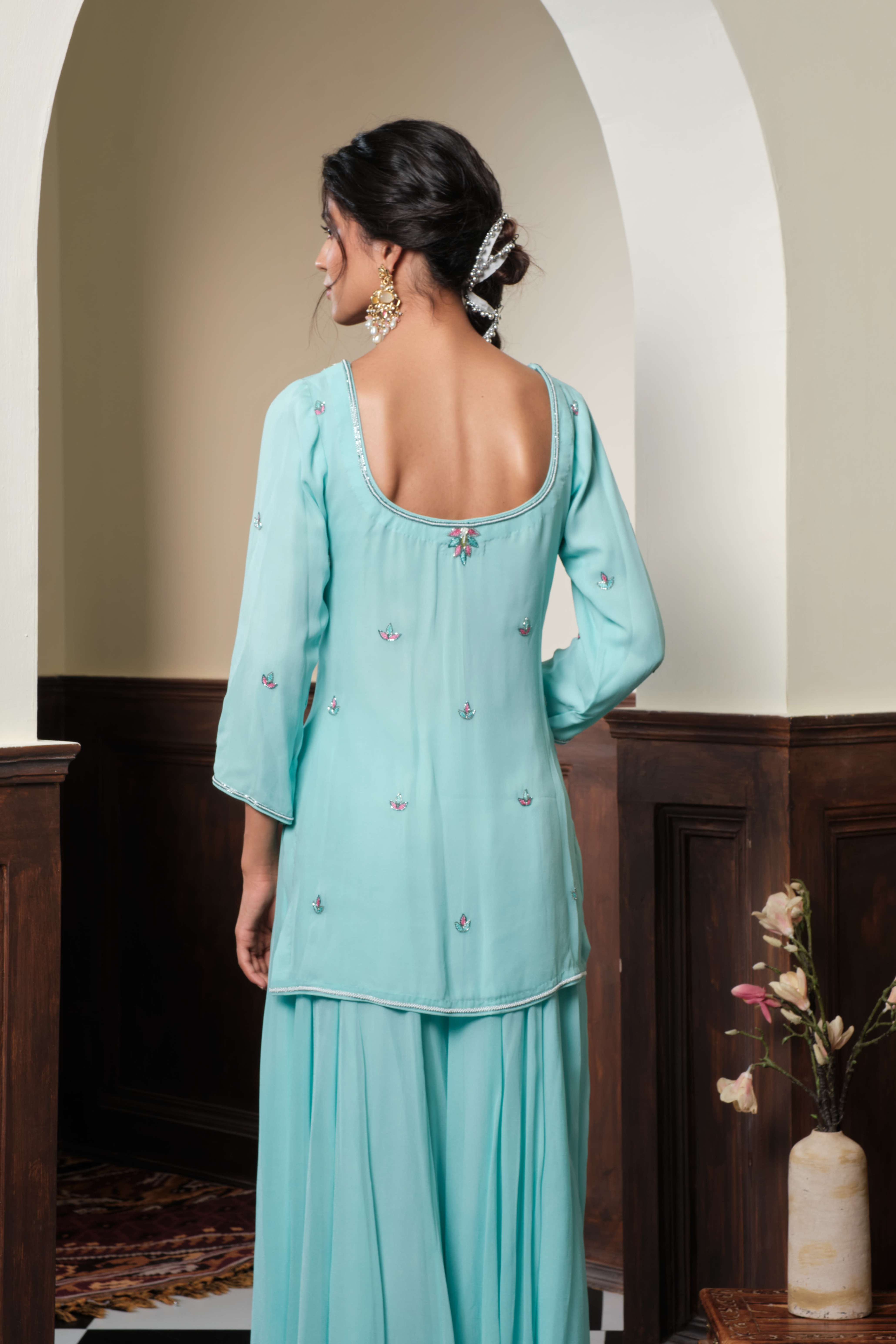 A model showcasing Meerika Pastel Blue Sharara Set by Muditaa By Urmila from Muditaa By Urmila's collection