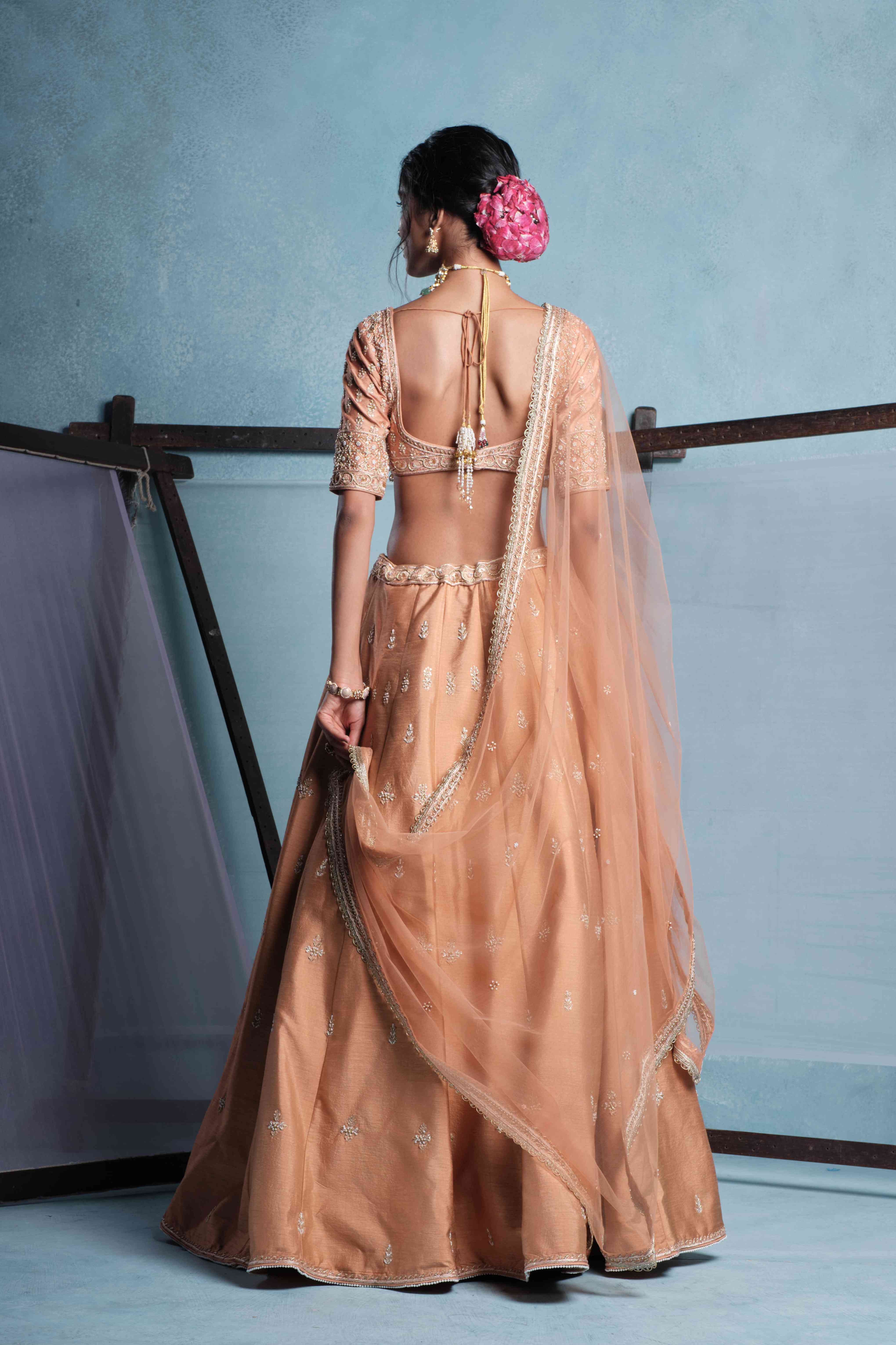 A model showcasing Ira Blush Nude Lehenga Set by Muditaa By Urmila from Muditaa By Urmila's collection