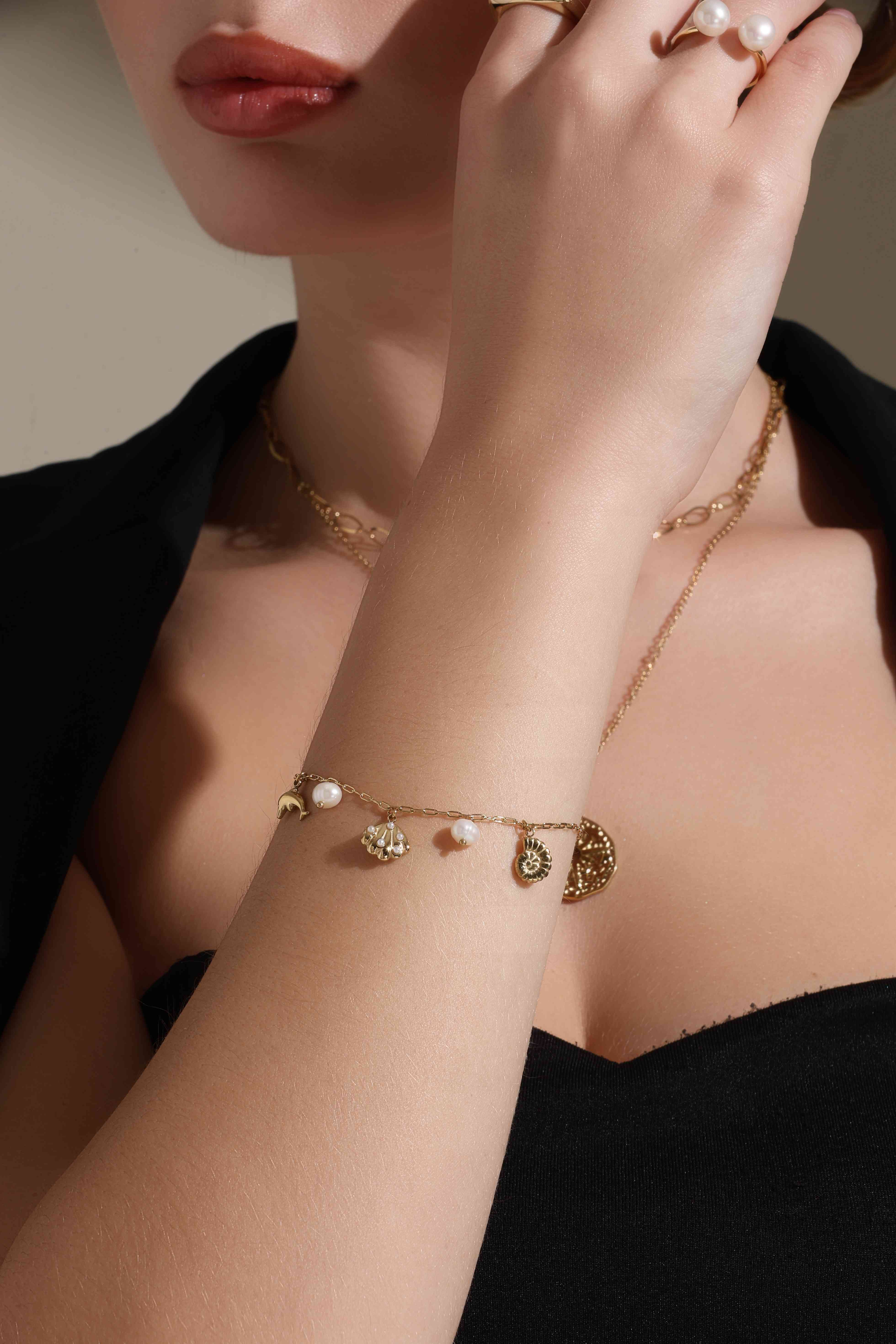 A model showcasing Pearl Beach Charm Bracelet by Dusala from Dusala's collection A model showcasing Pearl Beach Charm Bracelet by Dusala from Dusala's collection