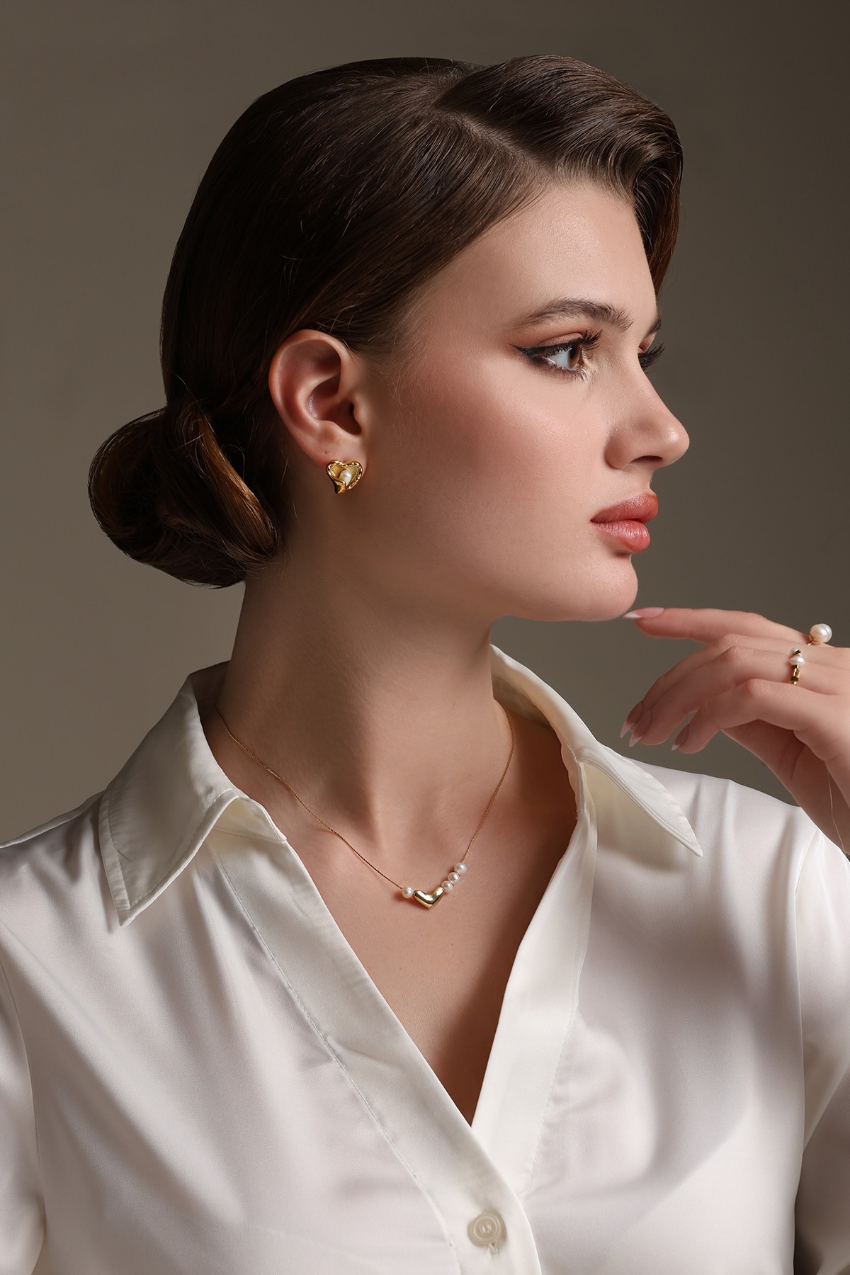 A model showcasing Golden Heartfealt Pearls Earrings by Dusala from Dusala's collection A model showcasing Golden Heartfealt Pearls Earrings by Dusala from Dusala's collection