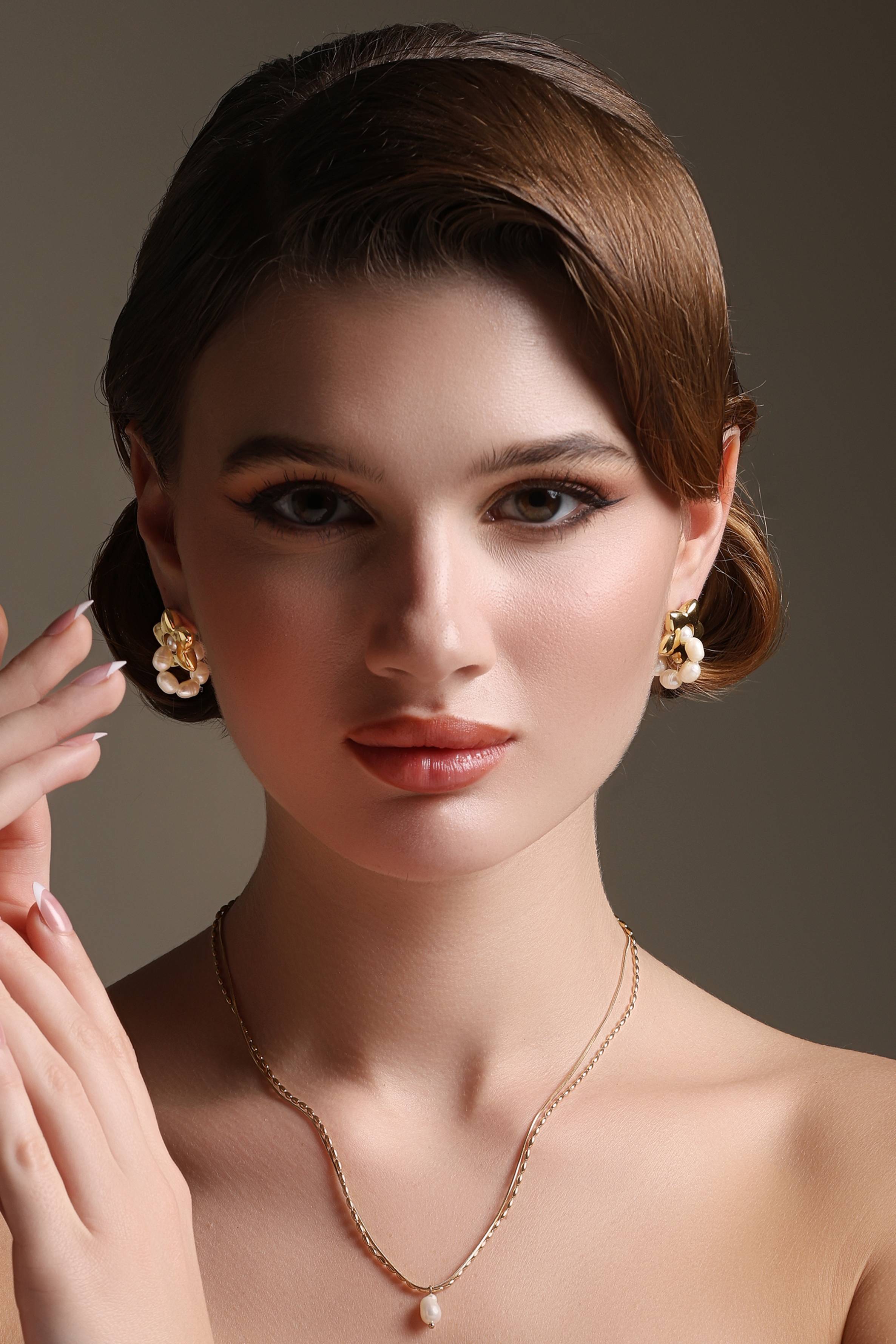 A model showcasing Starry Golden Luxe Earrings by Dusala from Dusala's collection A model showcasing Starry Golden Luxe Earrings by Dusala from Dusala's collection