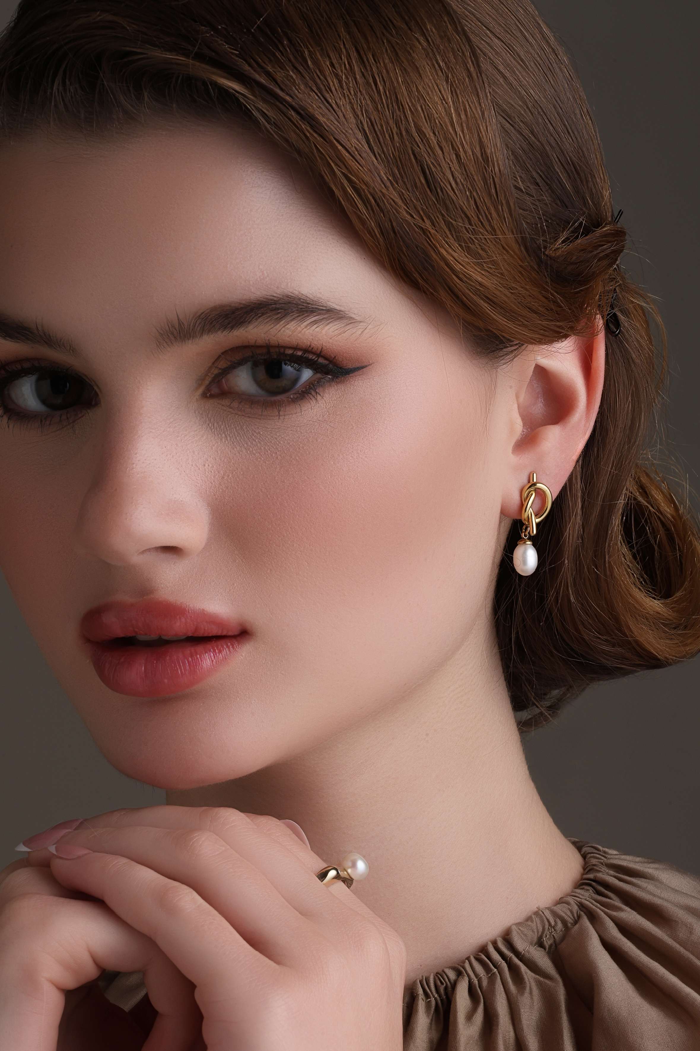A model showcasing Knot Sophistication Earrings by Dusala from Dusala's collection A model showcasing Knot Sophistication Earrings by Dusala from Dusala's collection