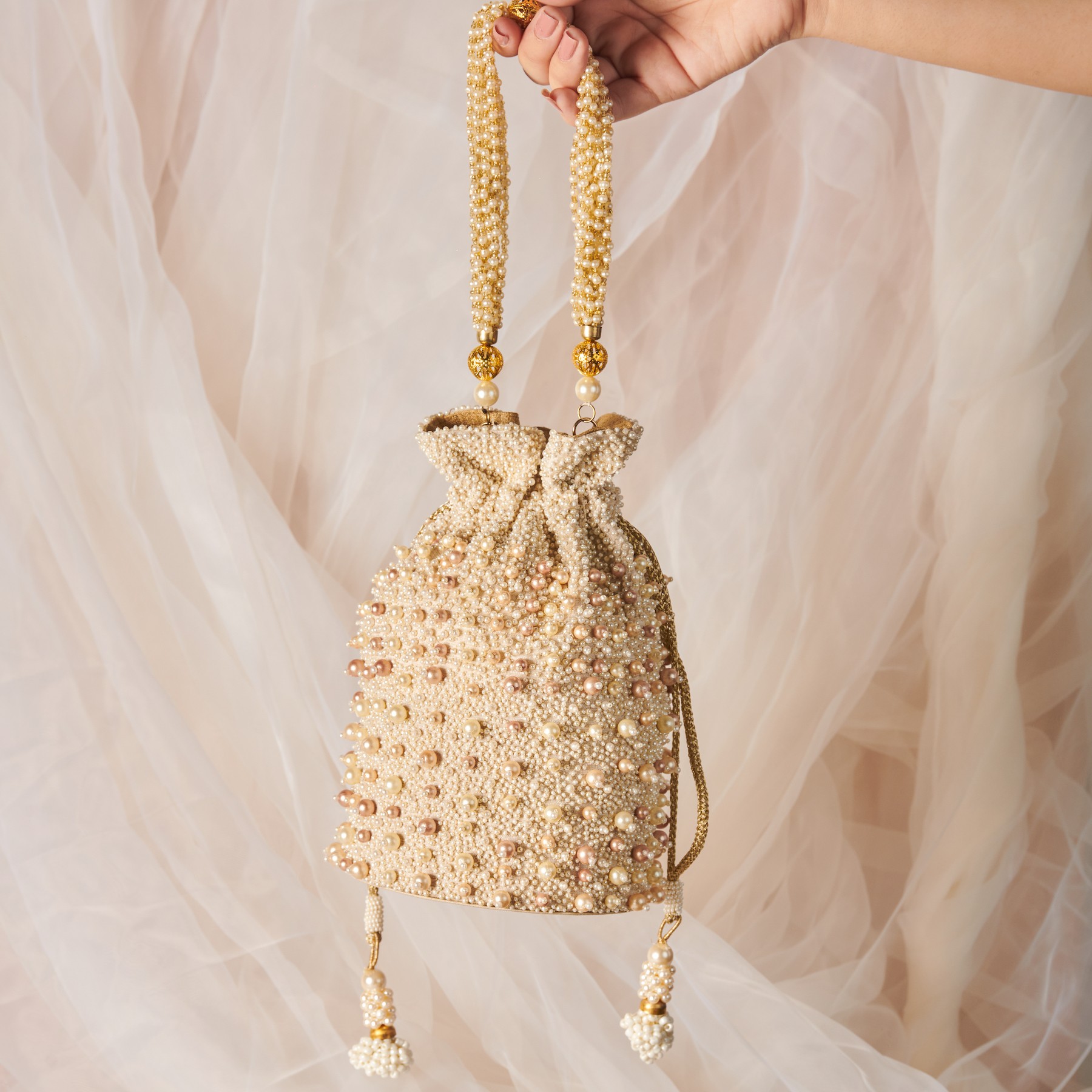 A model showcasing Sweet Pearls Potli by The Purple Sack from The Purple Sack's collection