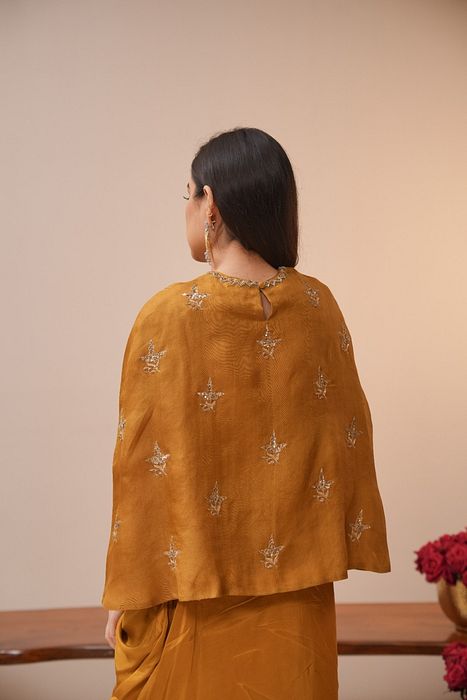 A model showcasing Mustard Cape And Dhoti Set by Myra By Anju Narian from Myra By Anju Narian's collection A model showcasing Mustard Cape And Dhoti Set by Myra By Anju Narian from Myra By Anju Narian's collection