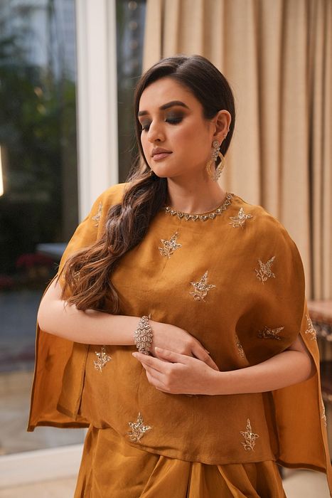A model showcasing Mustard Cape And Dhoti Set by Myra By Anju Narian from Myra By Anju Narian's collection A model showcasing Mustard Cape And Dhoti Set by Myra By Anju Narian from Myra By Anju Narian's collection
