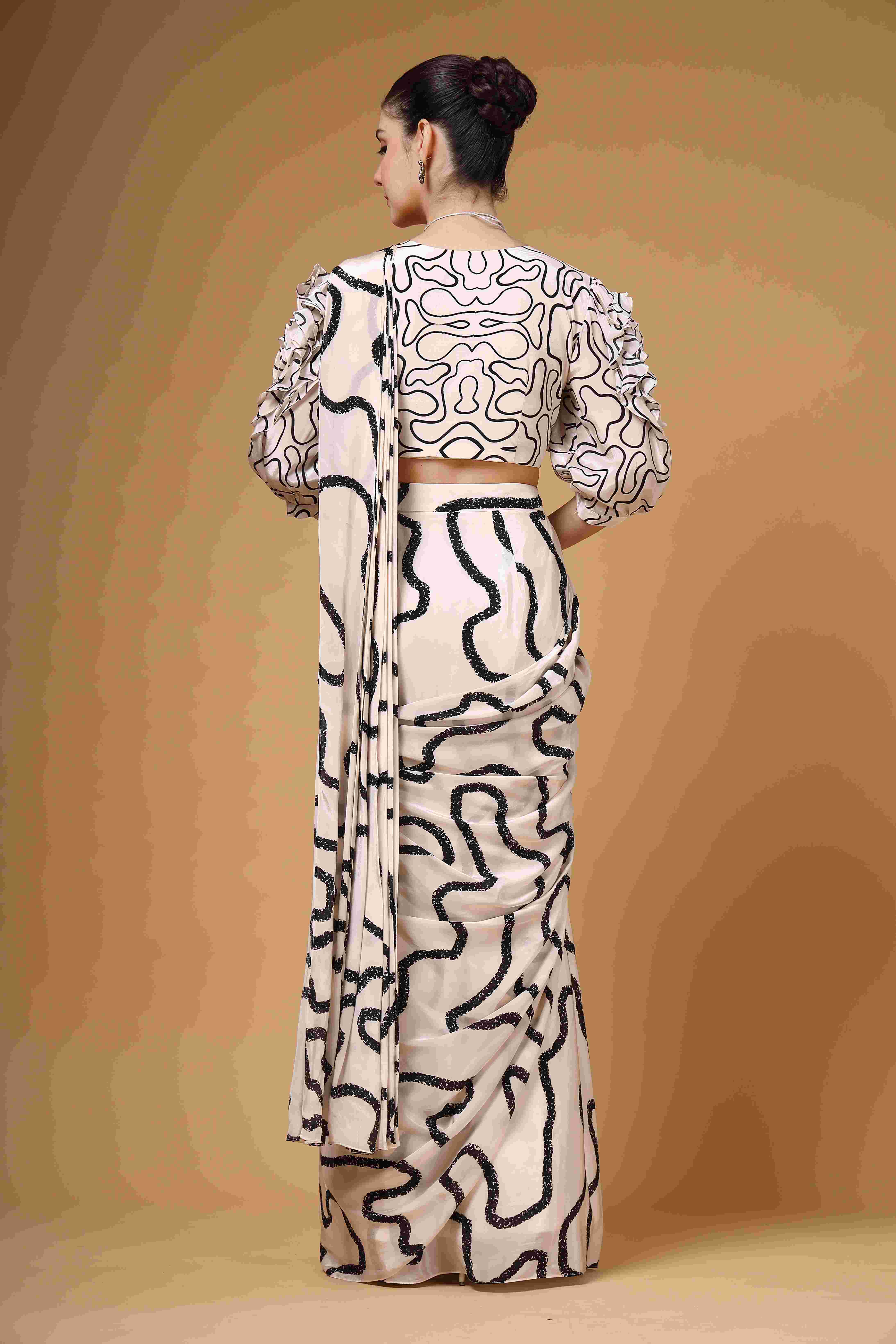 A model showcasing Lumea Ivory And Black Drape Saree by Miku Kumar from Miku Kumar's collection